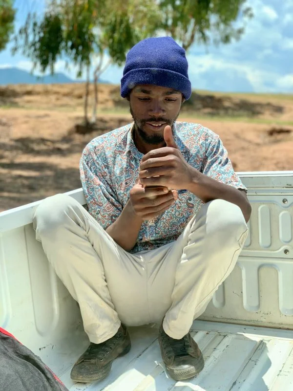 Peer educator D. rides on the back of the outreach vehicle after the outreach session in the lowlands of Leribe district.