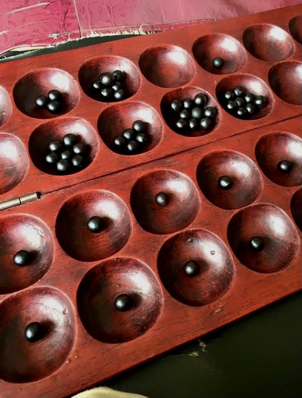 A traditional mancala board game inside the Kigali house. Residents often spent hours playing together while discussing politics, music and the future of Burundi.