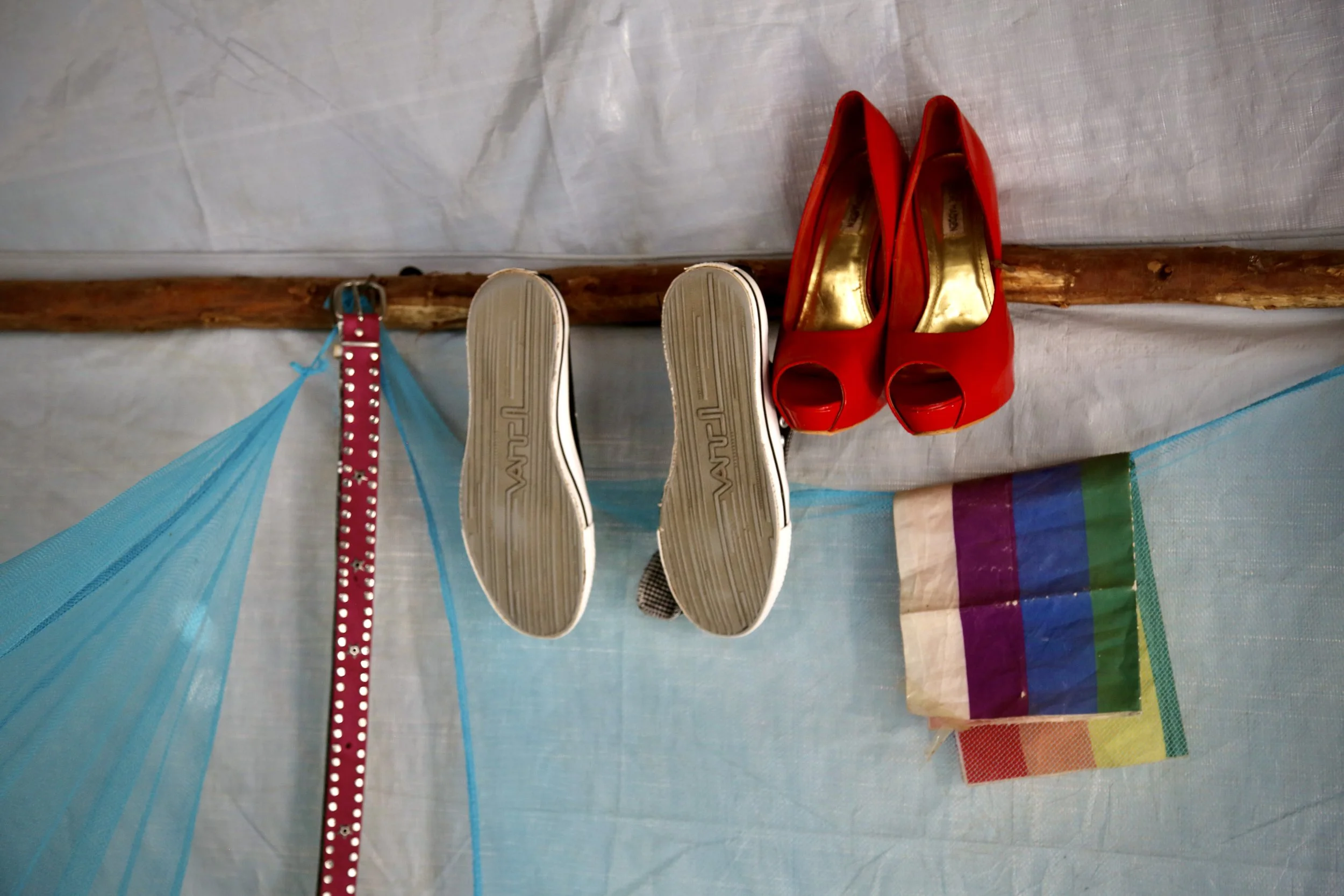 Shoes and a small rainbow flag hang inside a shelter in Kakuma refugee camp.