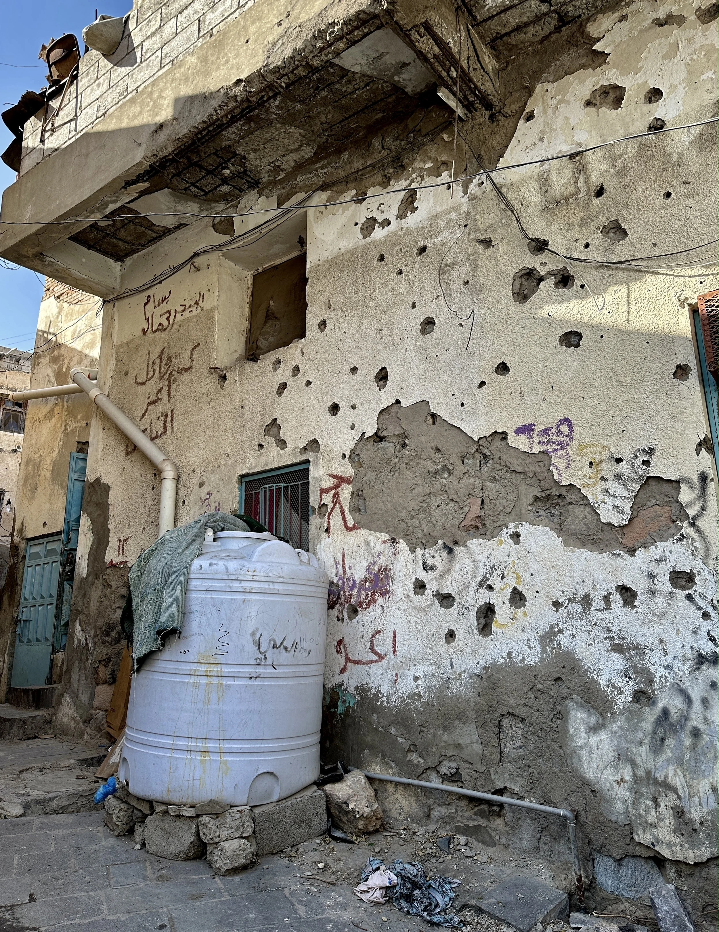 The facade of the apartment building where Dalila Abdo Ahmed lives bears scars from years of conflict in Taiz, Yemen. Dalila’s family were displaced from their land near the frontline after fighting reached the area.