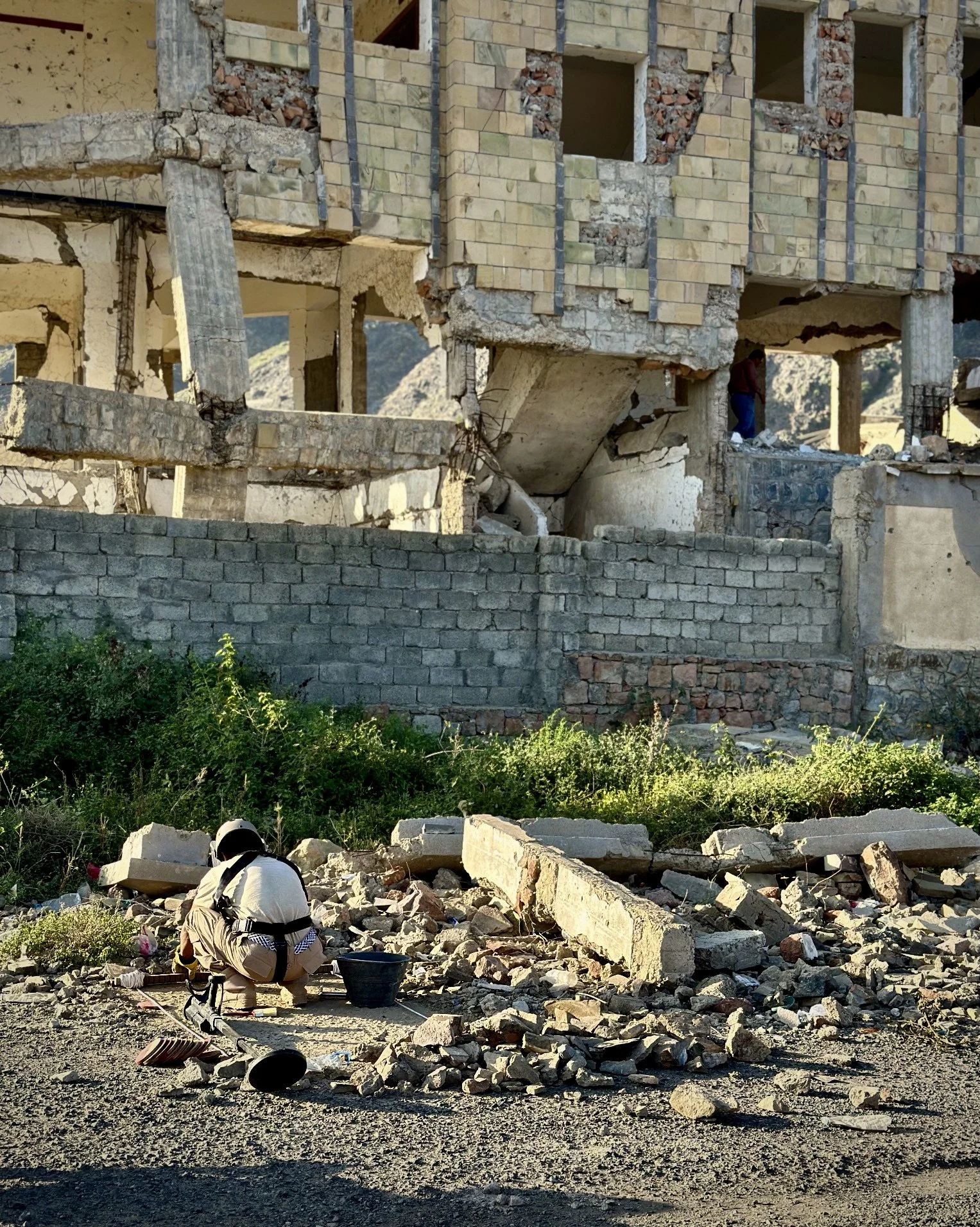 A deminer works near the damaged remains of Ibrahim Aqeel School in Taiz. Across the governorate, dozens of schools were mined or damaged during the conflict, according to Project Masam and local rights groups.