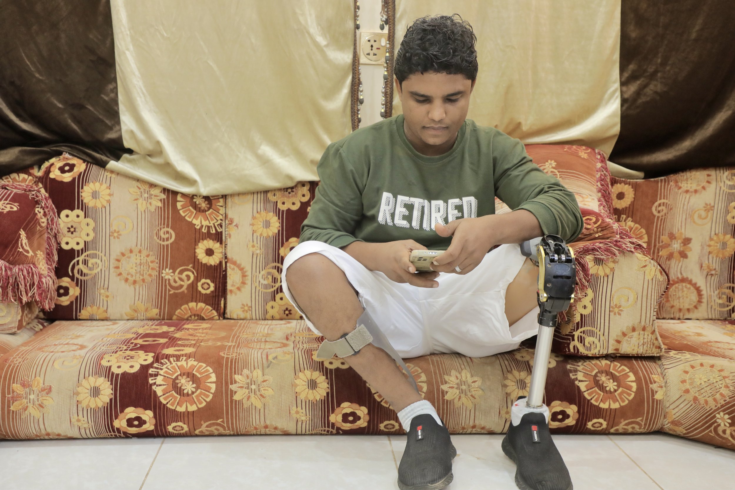 Mohamed Saeed Haimed, a former deminer injured in a landmine accident, sits inside his family home north of Al Khokha. His older brother Sami now works in mine clearance alongside other members of the family.
