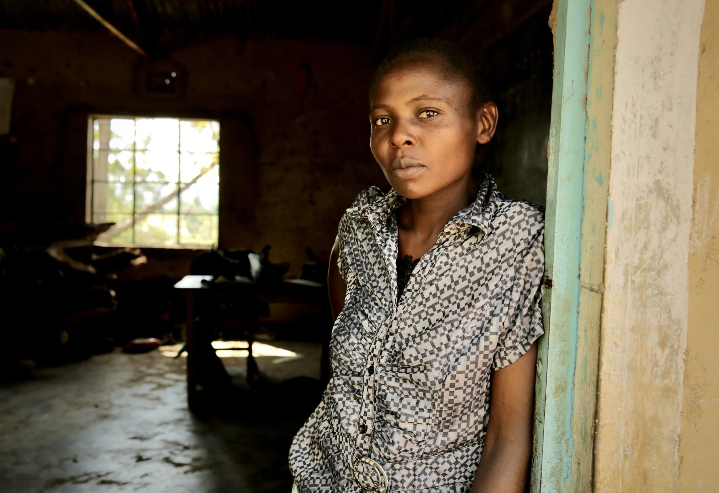 A teacher, Naomi Serenge, 40, stands inside a classroom at Shinyunzu Primary School in Kakamega County, Kenya. A teacher there for seven years, she said girls as young as nine drop out of school due to issues surrounding water, illnesses, finances an
