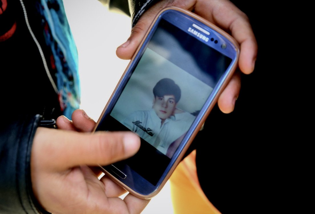 Mamad shows a photograph of his teenage cousin on his mobile phone inside the Calais camp. Mamad claimed his cousin - the only relative travelling with him - died after being shot by Iranian police during their journey toward Europe.