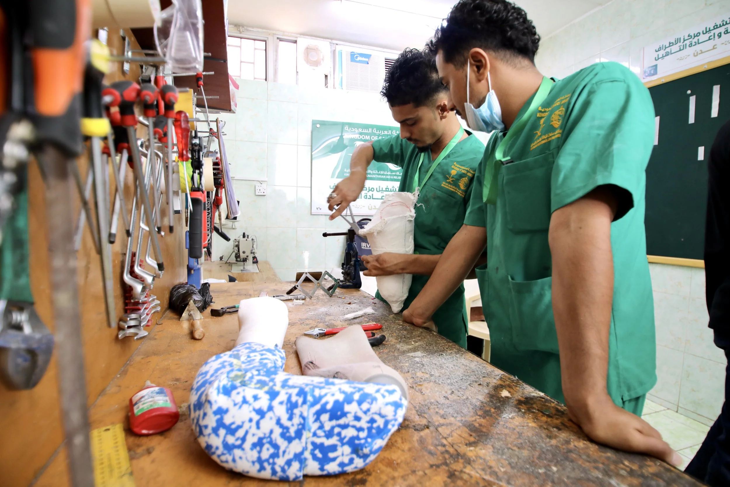 Technicians shape prosthetic moulds inside the workshop where artificial limbs are fabricated largely by hand at the rehabilitation centre in Aden.