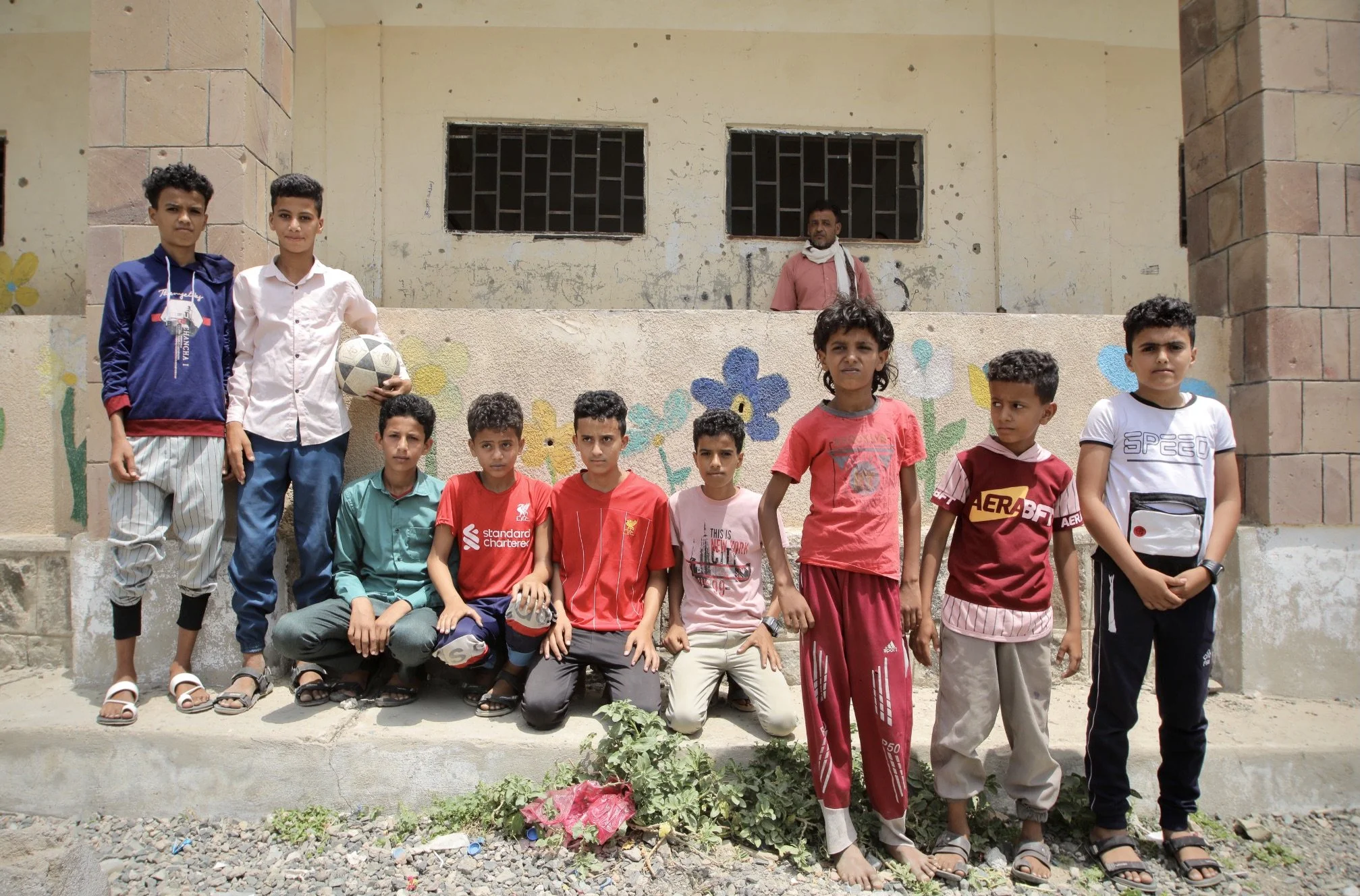Students gather outside damaged classrooms at Ibrahim Aqeel School in Taiz, Yemen. Parts of the school were destroyed after Houthi forces used the site to store landmines and improvised explosive devices during the conflict.
