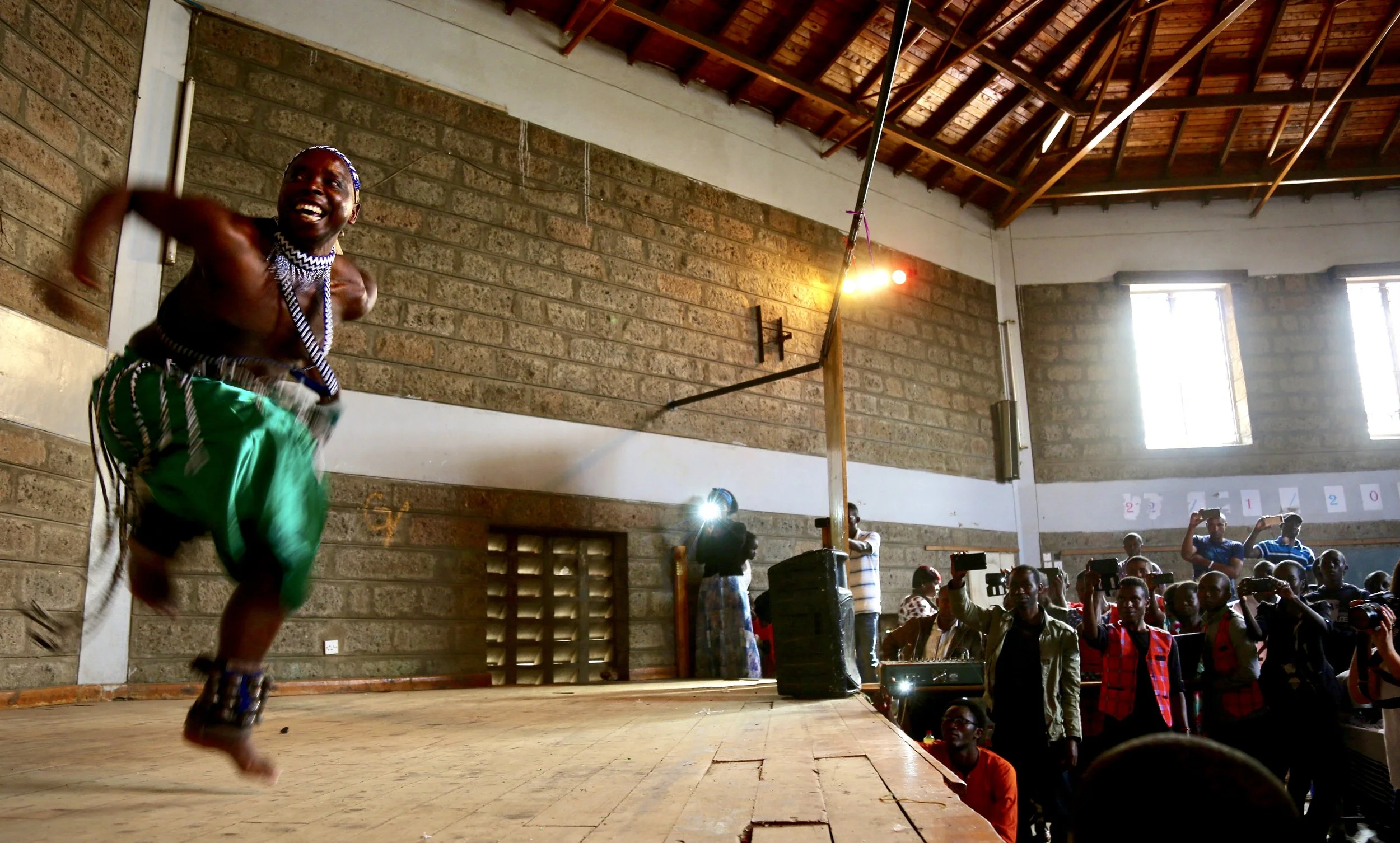 A performer leaps across the stage during a traditional dance presentation at Divine Word Church in Nairobi.