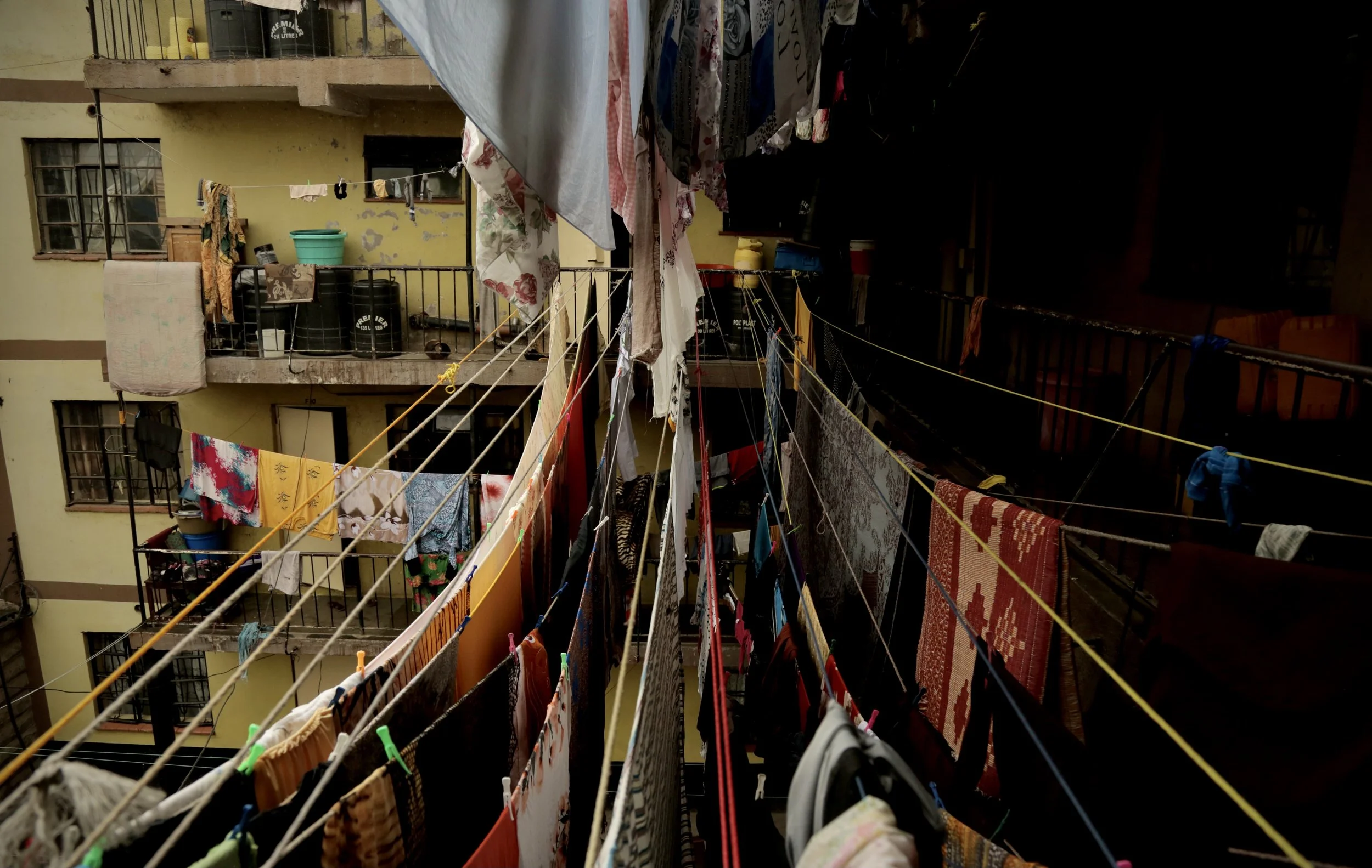Laundry hangs across the courtyard of an apartment block in Eastleigh, Nairobi, in which four sisters have been living. The neighbourhood became a refuge for Somali families seeking to live outside Kenya's refugee camps. Nairobi, Kenya, June 2016.