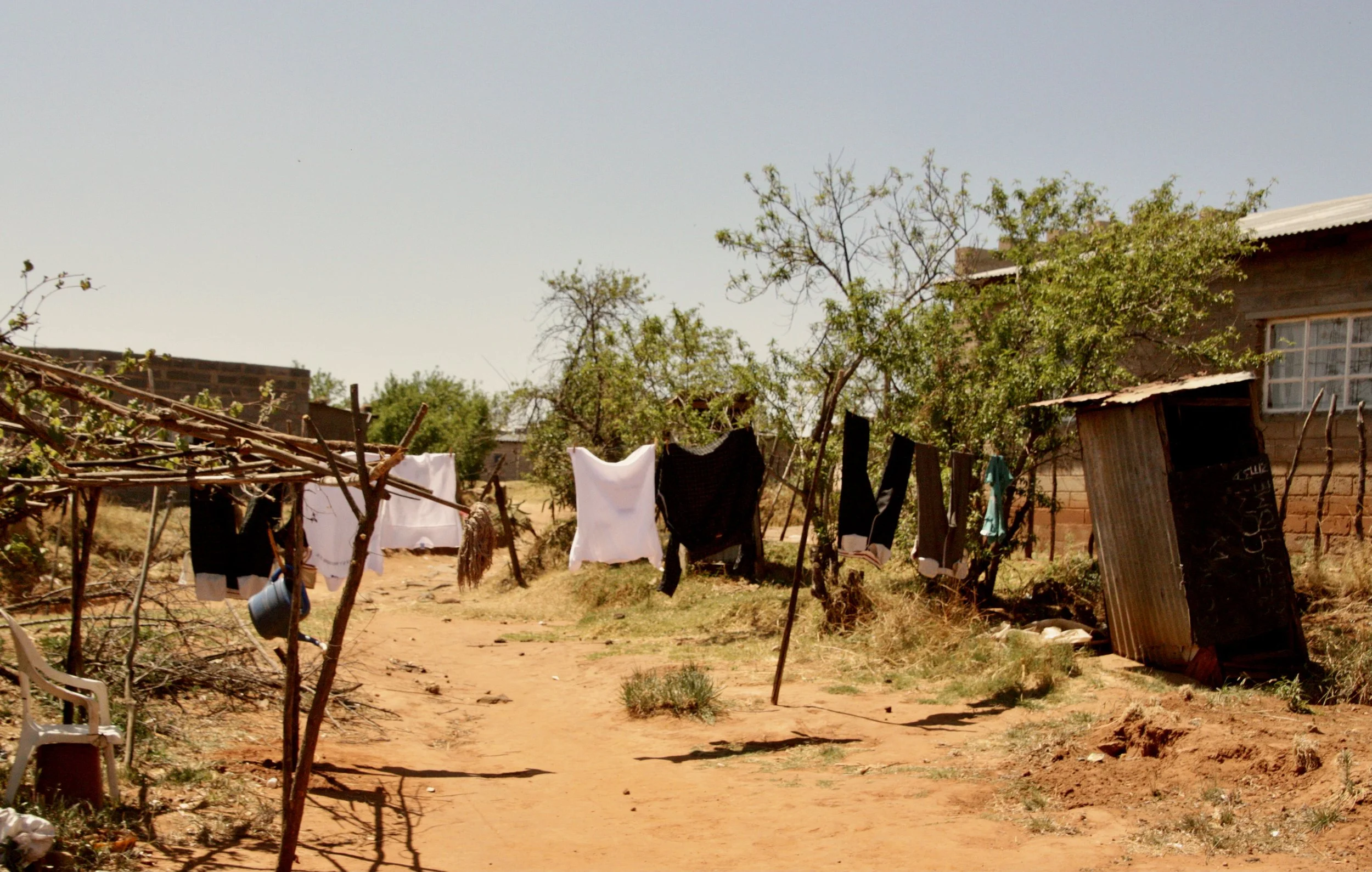 A narrow path runs between homes in the village of Ha Chonapase in Leribe District, where poverty and unemployment remain widespread. Michael says many children in the area are left vulnerable after losing parental care, often because of illness, mig