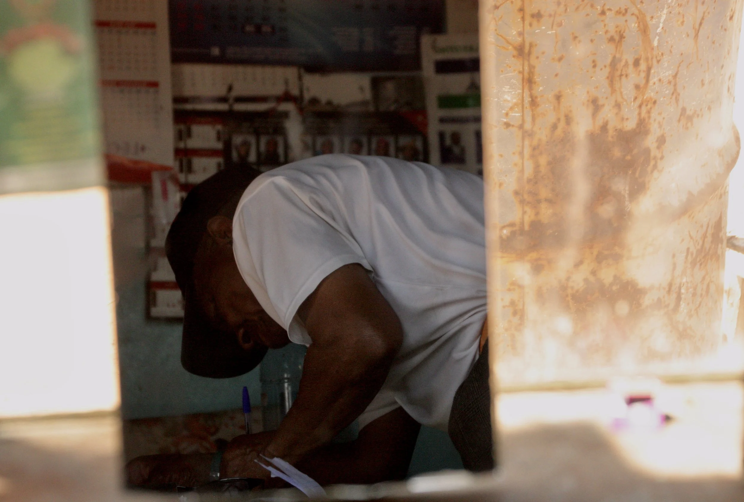 Michael bends over paperwork during a visit connected to school support and case management assistance. Through Sentebale’s OVC programme, Beauty was linked to government sponsorship support for school fees, though administrative disputes later place