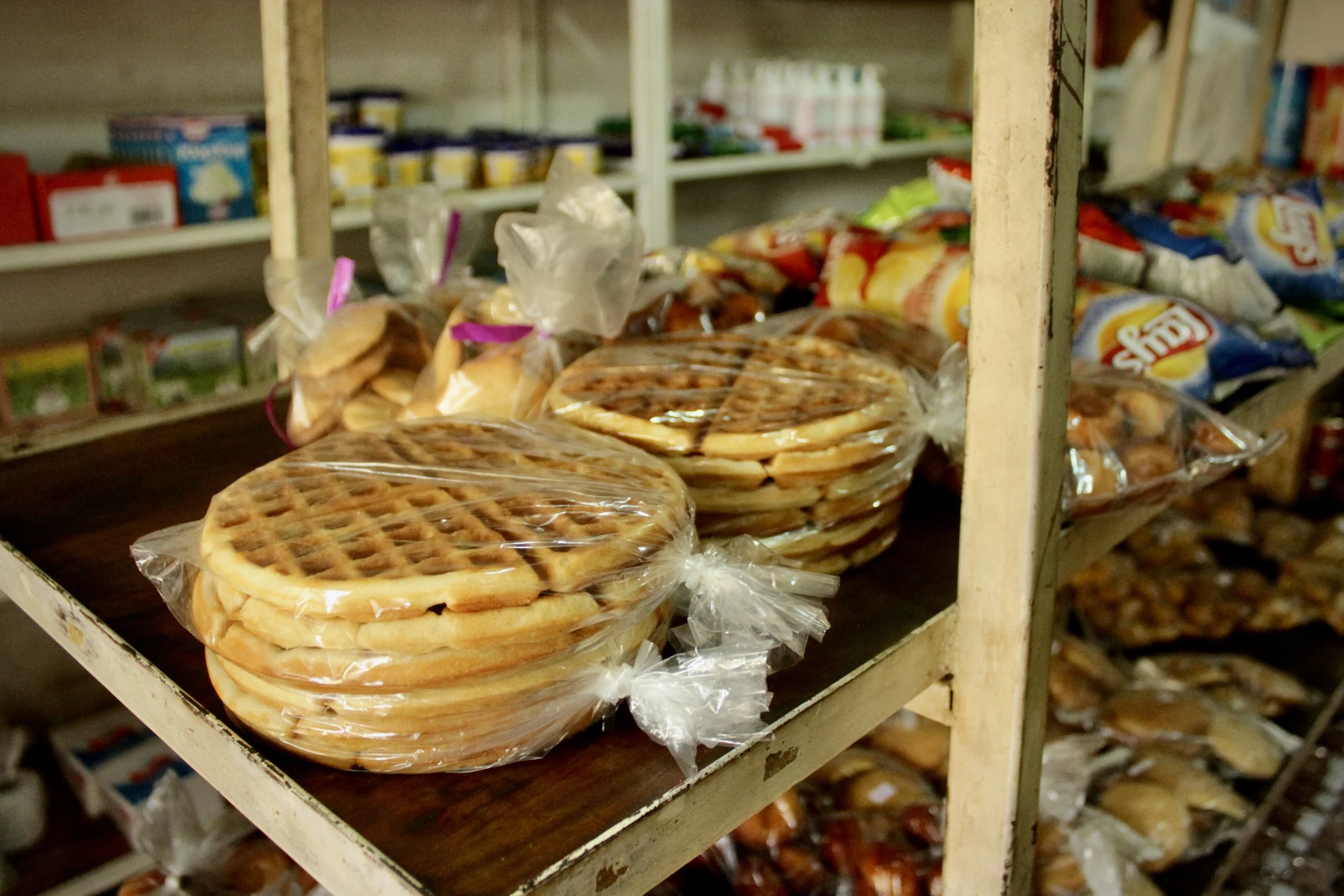 Packaged baked goods sit unsold on the shelves of the Fido Dido grocery store in Rohero I. Employees said products that would previously have sold within days had remained on shelves for months.