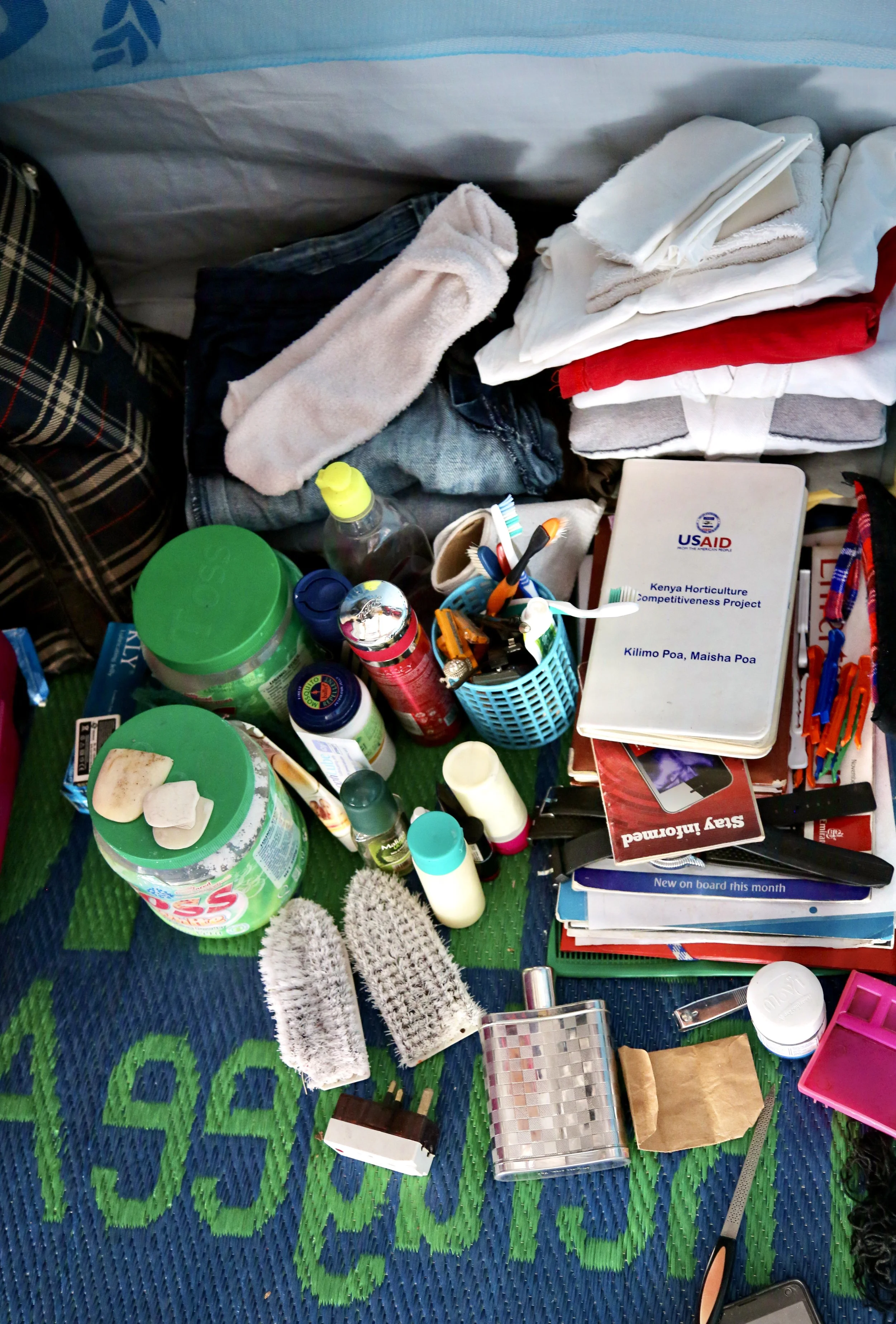Personal belongings inside Charles Itwara’ shelter include cosmetics, notebooks, toiletries and folded clothes. Charles, a transgender refugee from Uganda, said maintaining small routines helped her preserve dignity and identity amid displacement.