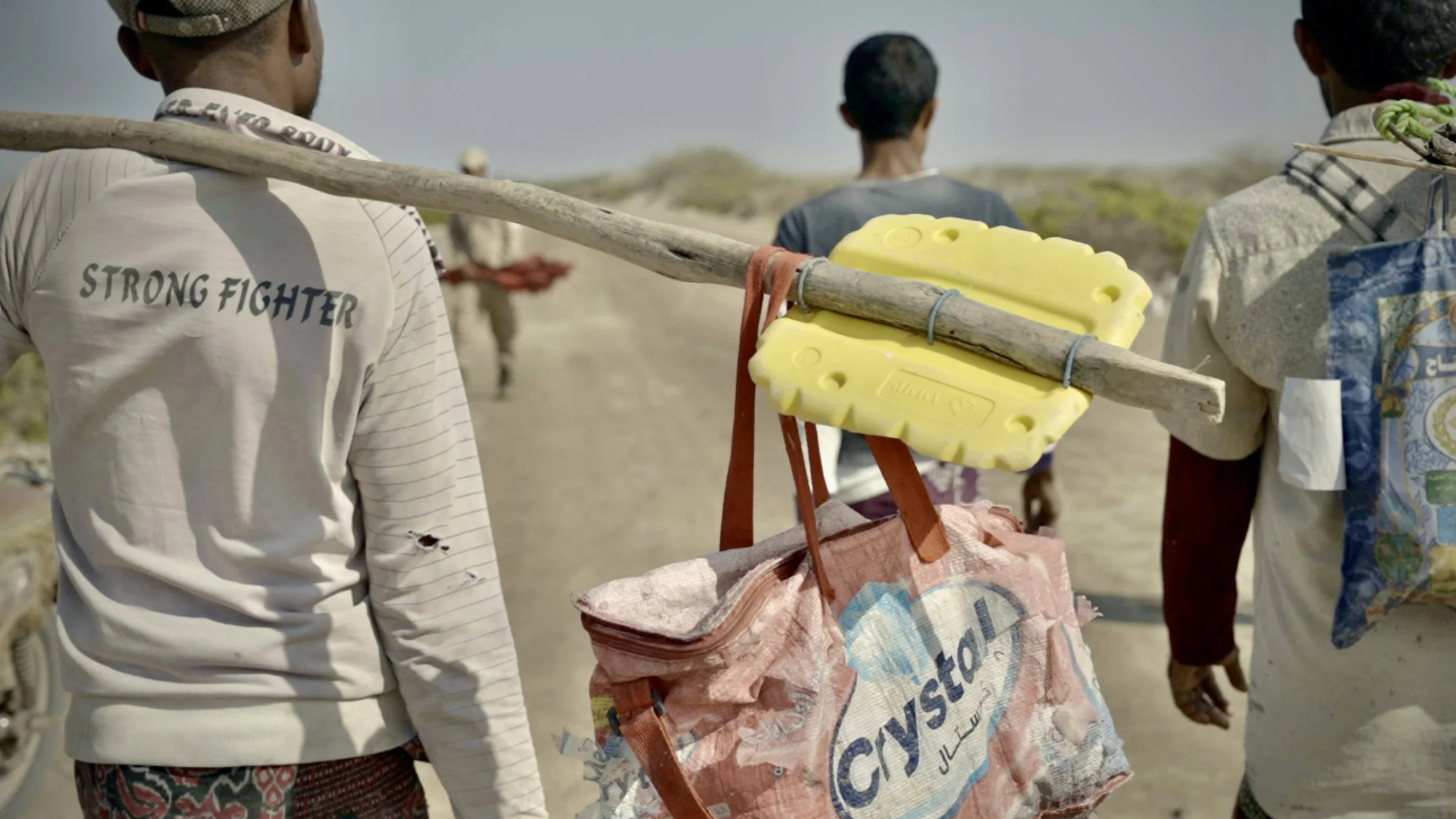 Fishermen walk along Yemen’s Red Sea coast carrying nets and equipment near Al Khokha, where communities already living with landmines and naval mines faced renewed fear during escalating Red Sea tensions and Houthi attacks in 2024.