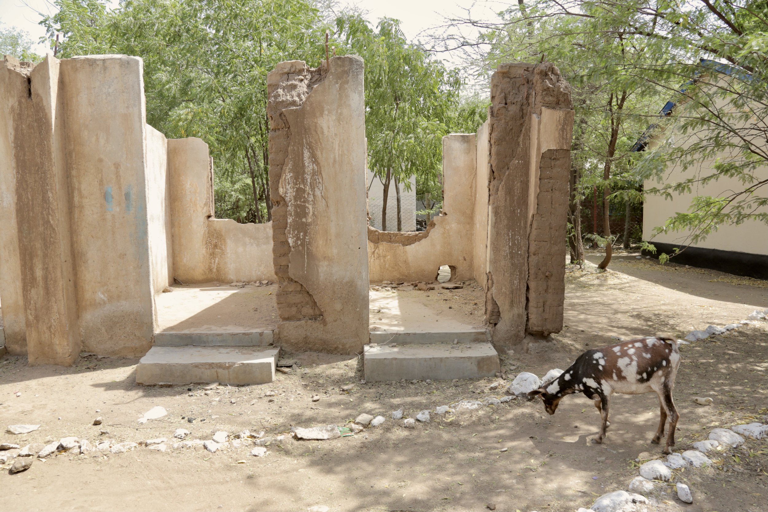 A ruined structure stands beside the area where Fidele Wabenga, 16, operated his studio in Kakuma Refugee Camp, Kenya. The surroundings reflect the scarcity and impermanence of camp life, in contrast to the ambition growing inside.