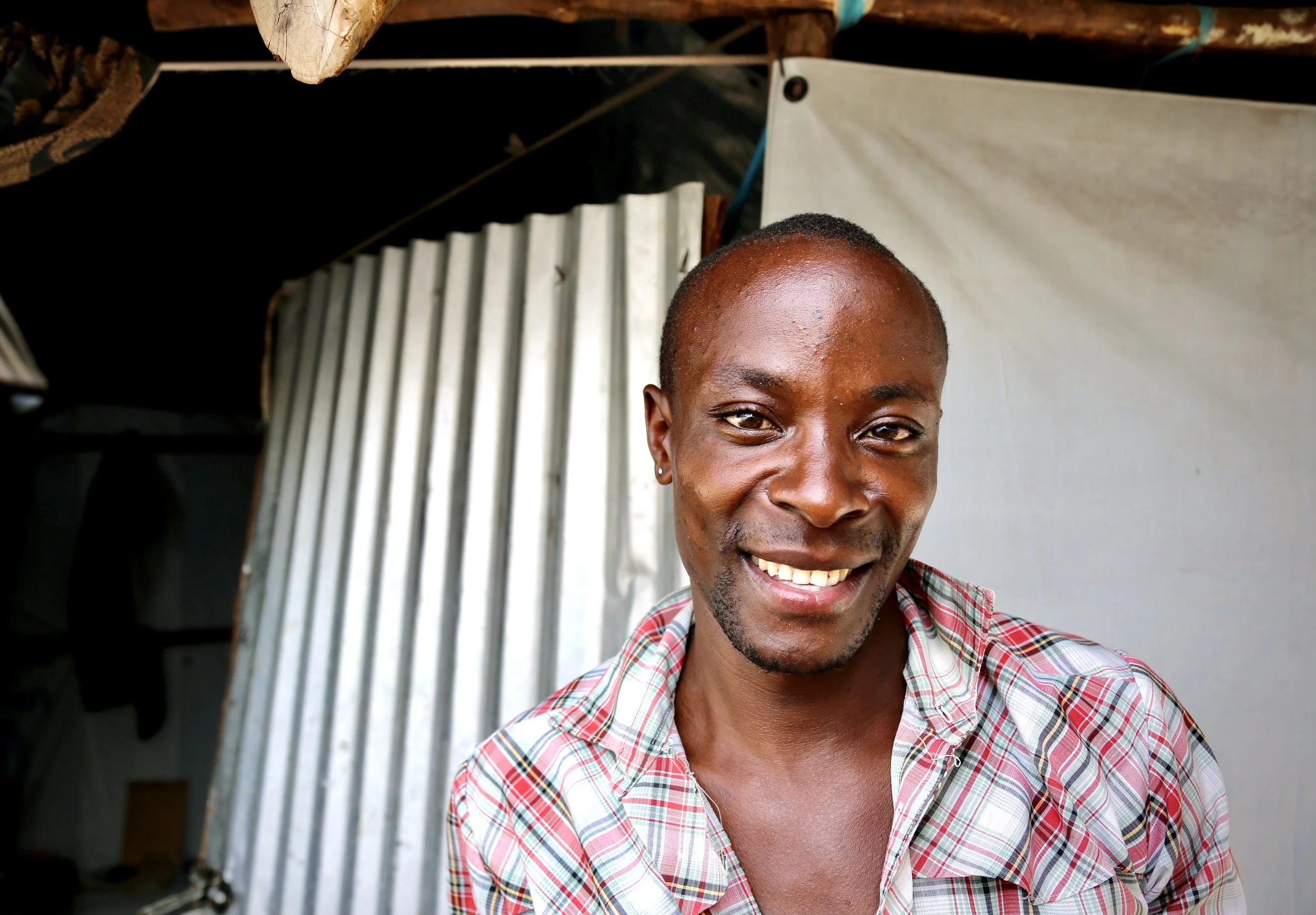 "David" stands outside his shelter in Kakuma refugee camp.