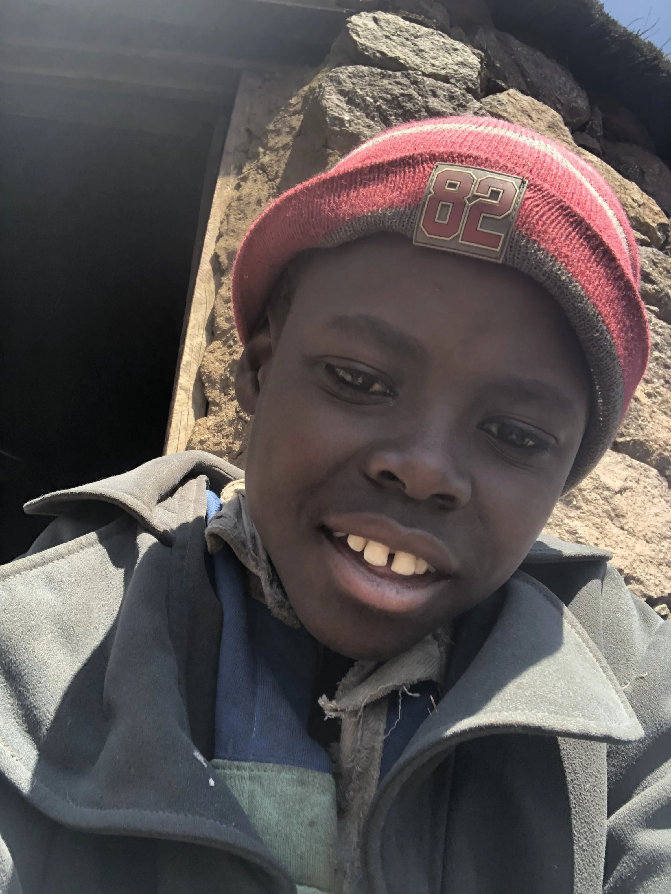 Bokang Khera poses outside the hut he shared with an elderly caregiver in the mountains of southern Lesotho. Though physically small for his age because of malnutrition, he was approximately 15 or 16 years old and had only attended school up to Class