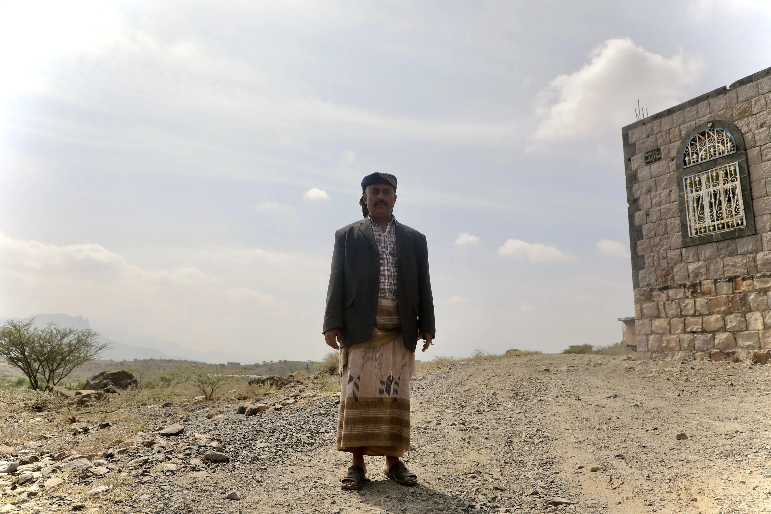 Saleh Abdullah Qassem, local chieftain of Qatabah, Al Dhale Governorate, outside his home. Members of his family were killed and injured by landmines and booby-traps planted inside the family compound. He stands on the ground where demining teams sub