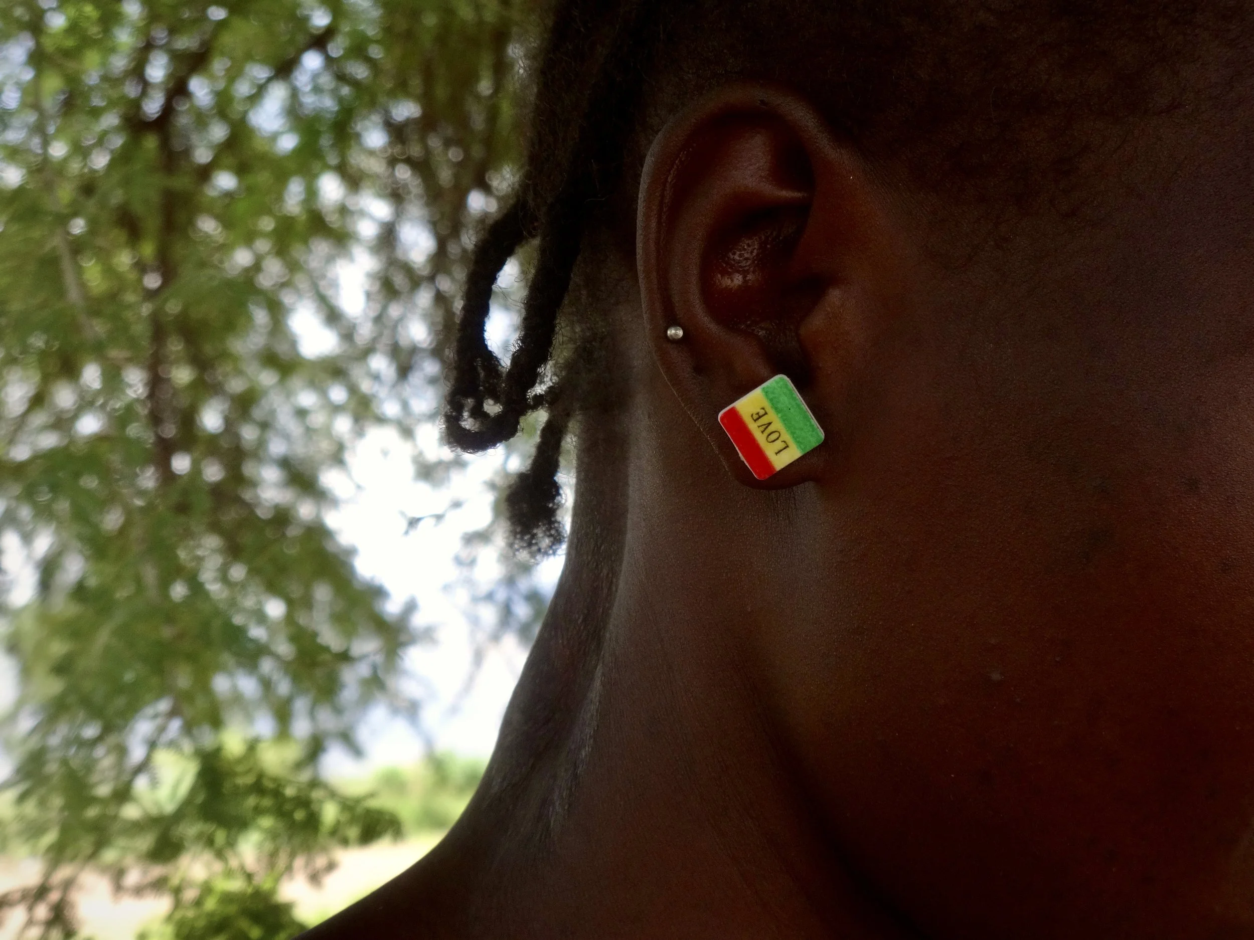 A close detail of Randa’s earring reading “Love” as she waits to cross into Kenya.