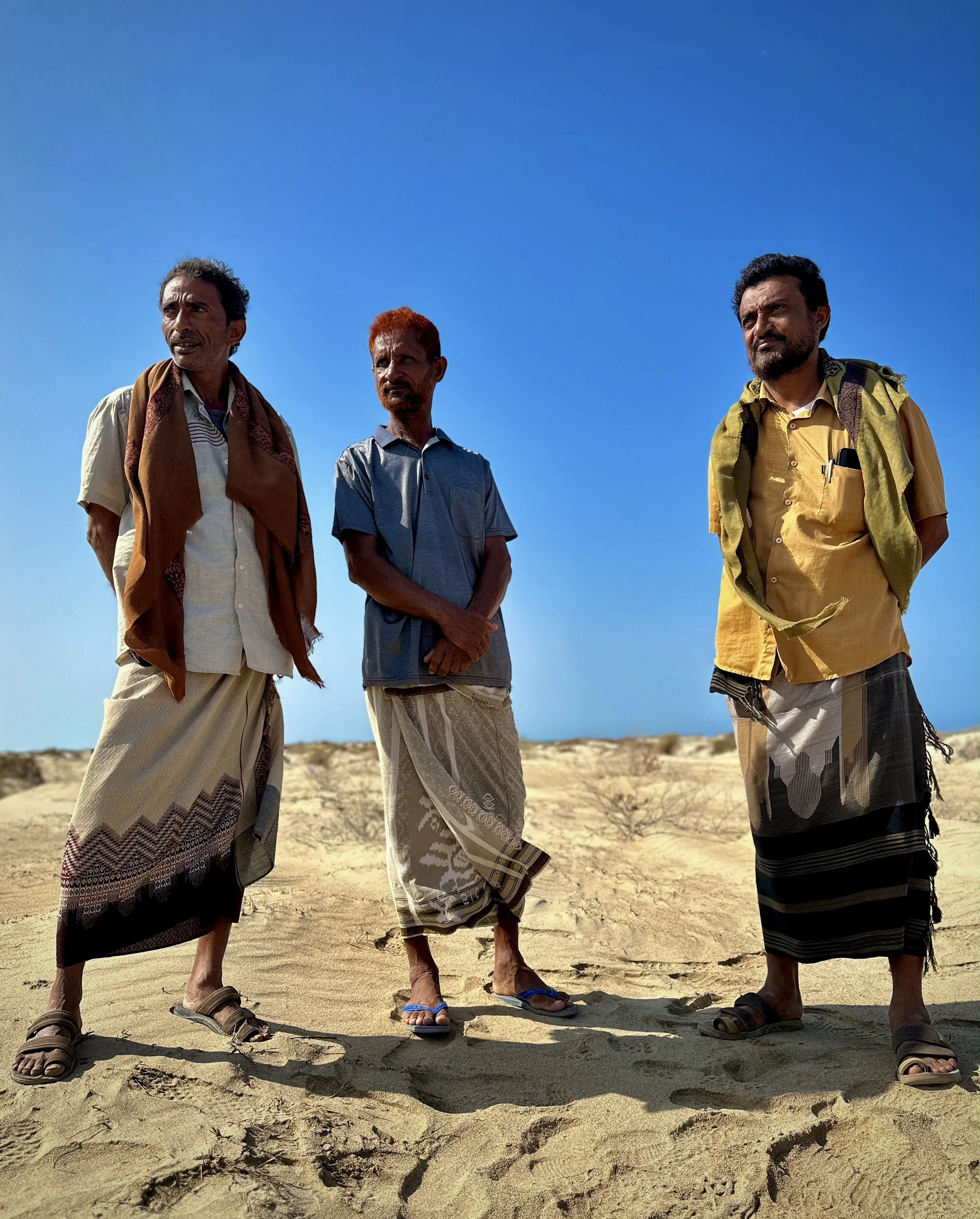 Fishermen stand along the shoreline in Al Khokha, where naval mines, water-borne explosive devices and years of conflict have transformed once-active fishing grounds into dangerous territory.