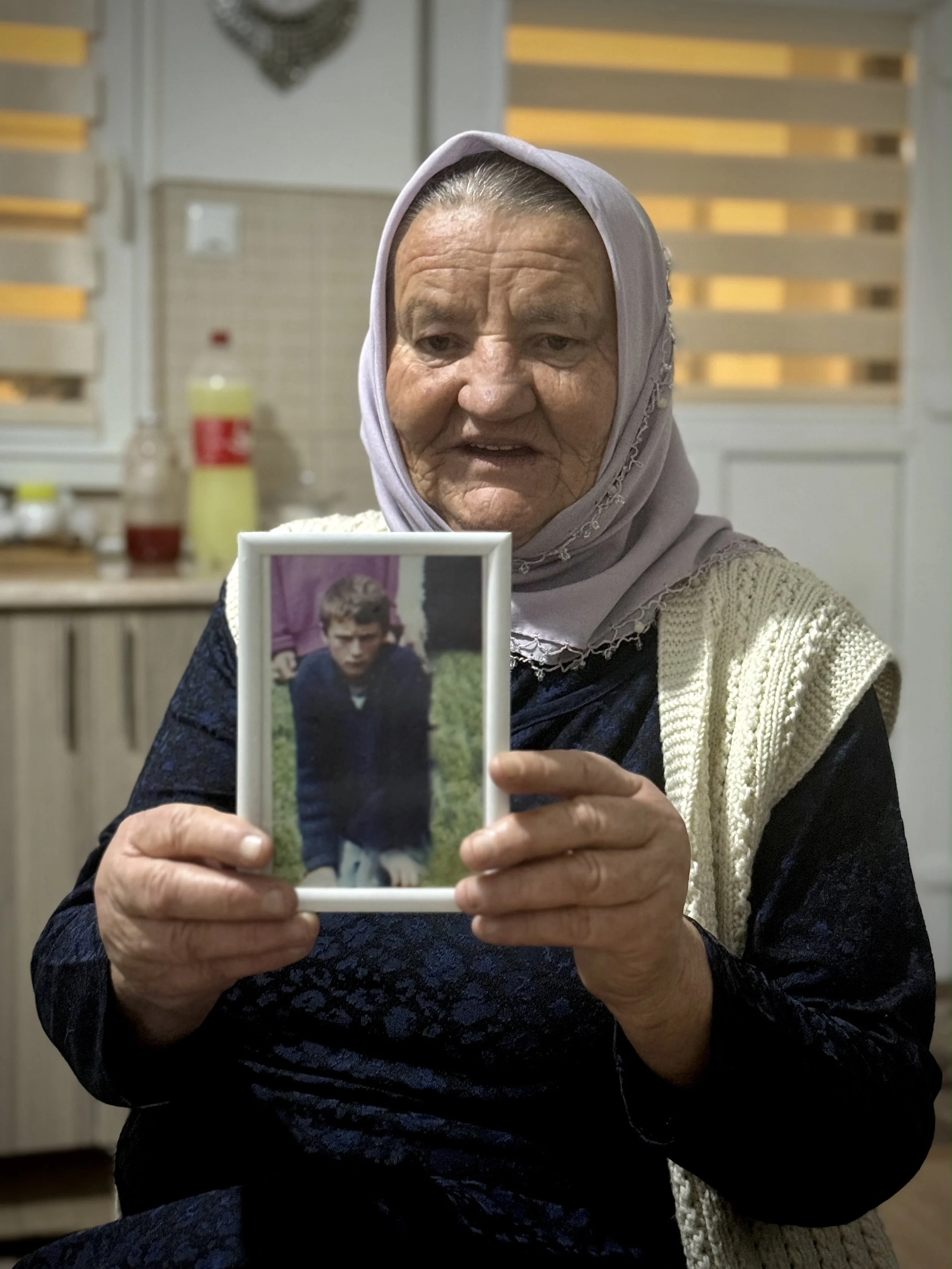 Saliha Osmanović holding a photograph of one of her murdered sons at her home in Dobrak, Bosnia and Herzegovina.
Her youngest son Edin was killed during the shelling of Srebrenica in July 1995. Days later, her husband Ramo and elder son Nermin were c