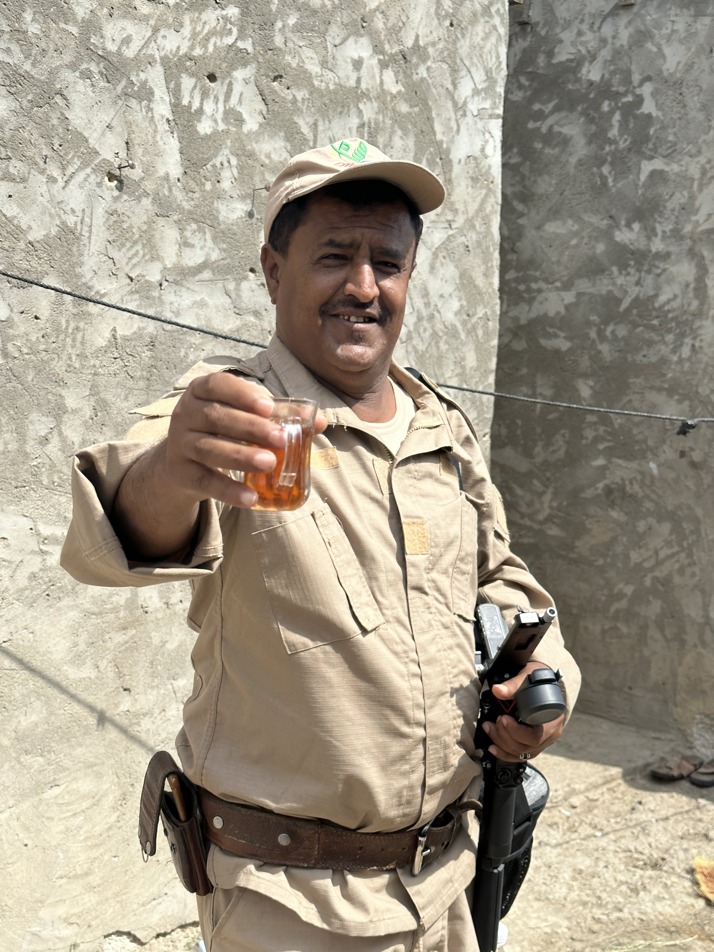A Project Masam deminer, Al Dhale Governorate. The teams are on first-name terms with the families whose land they clear. The offer of tea - the gesture of hospitality extended even in the field - speaks to the relationships built between deminers an
