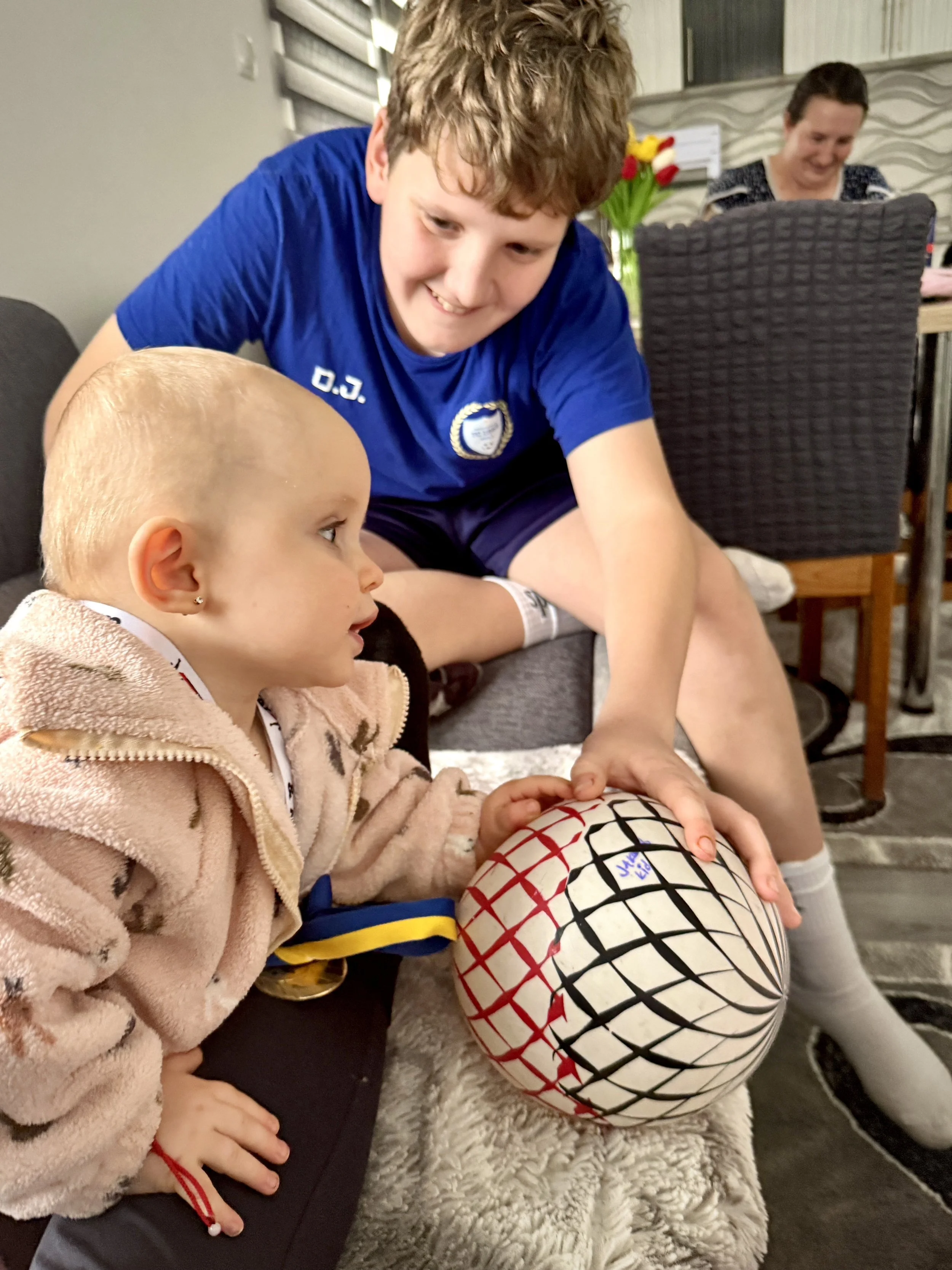 Mirnesa’s son plays at home and dreams of becoming a professional footballer. He knows the history that shaped his family and belongs to a generation growing up with inherited memory and their own ambitions.