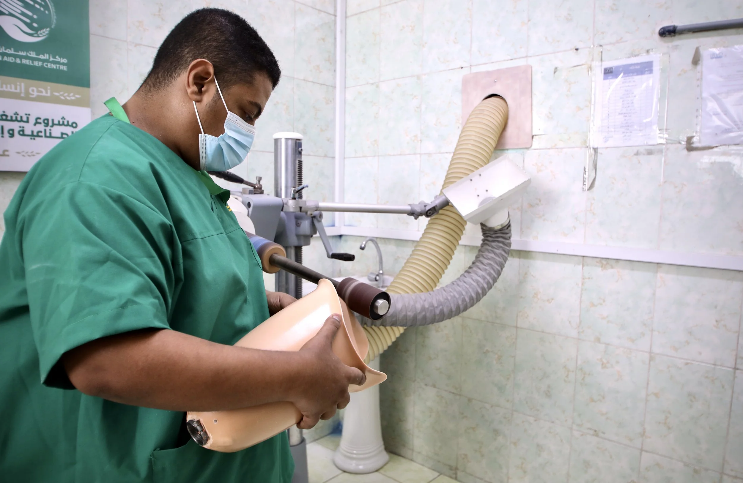 A technician sands and smooths a prosthetic socket inside the workshop at the Artificial Limbs and Rehabilitation Centre in Aden, Yemen.