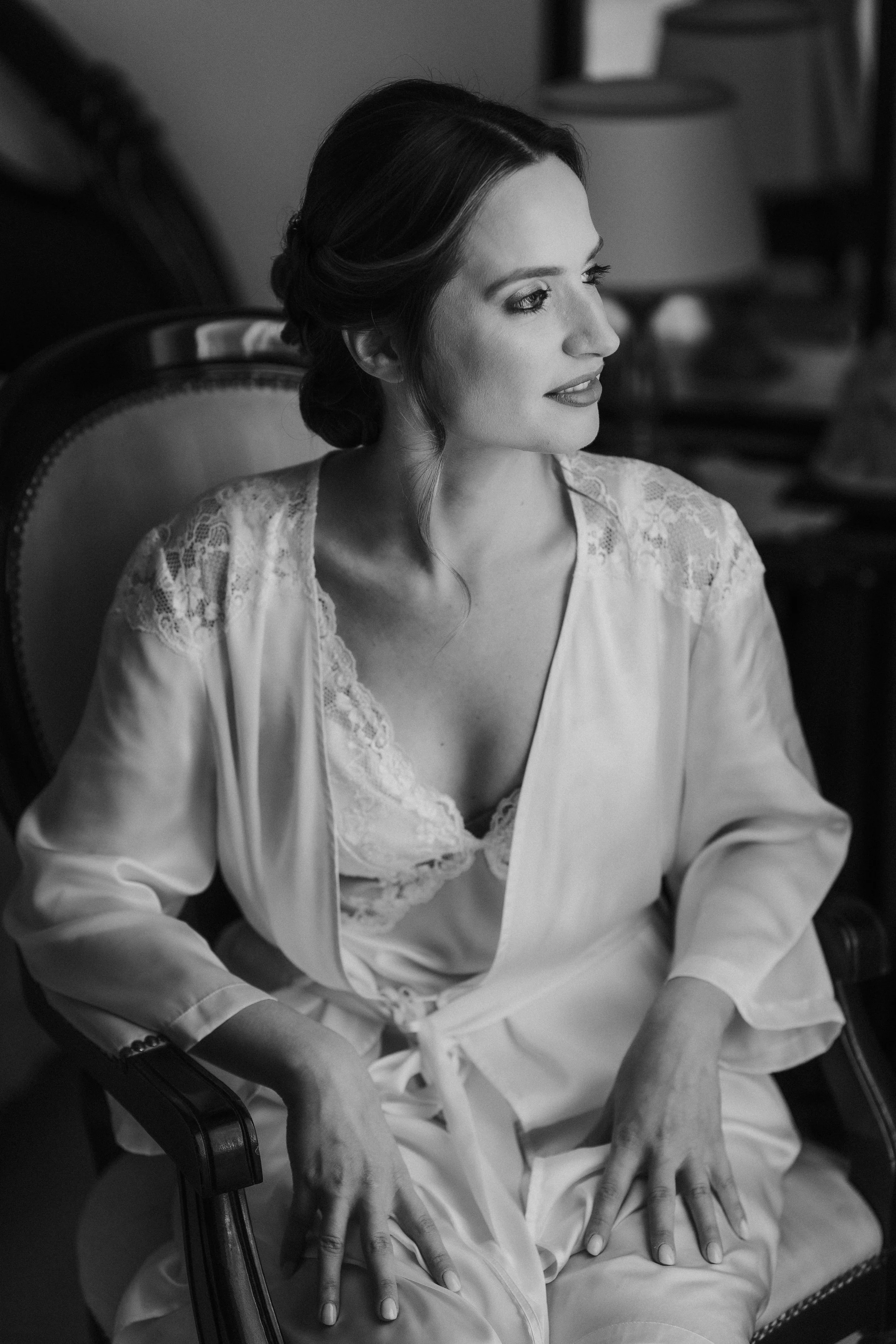 Ritratto di una donna con abiti eleganti, seduta su una sedia, in una foto in bianco e nero.