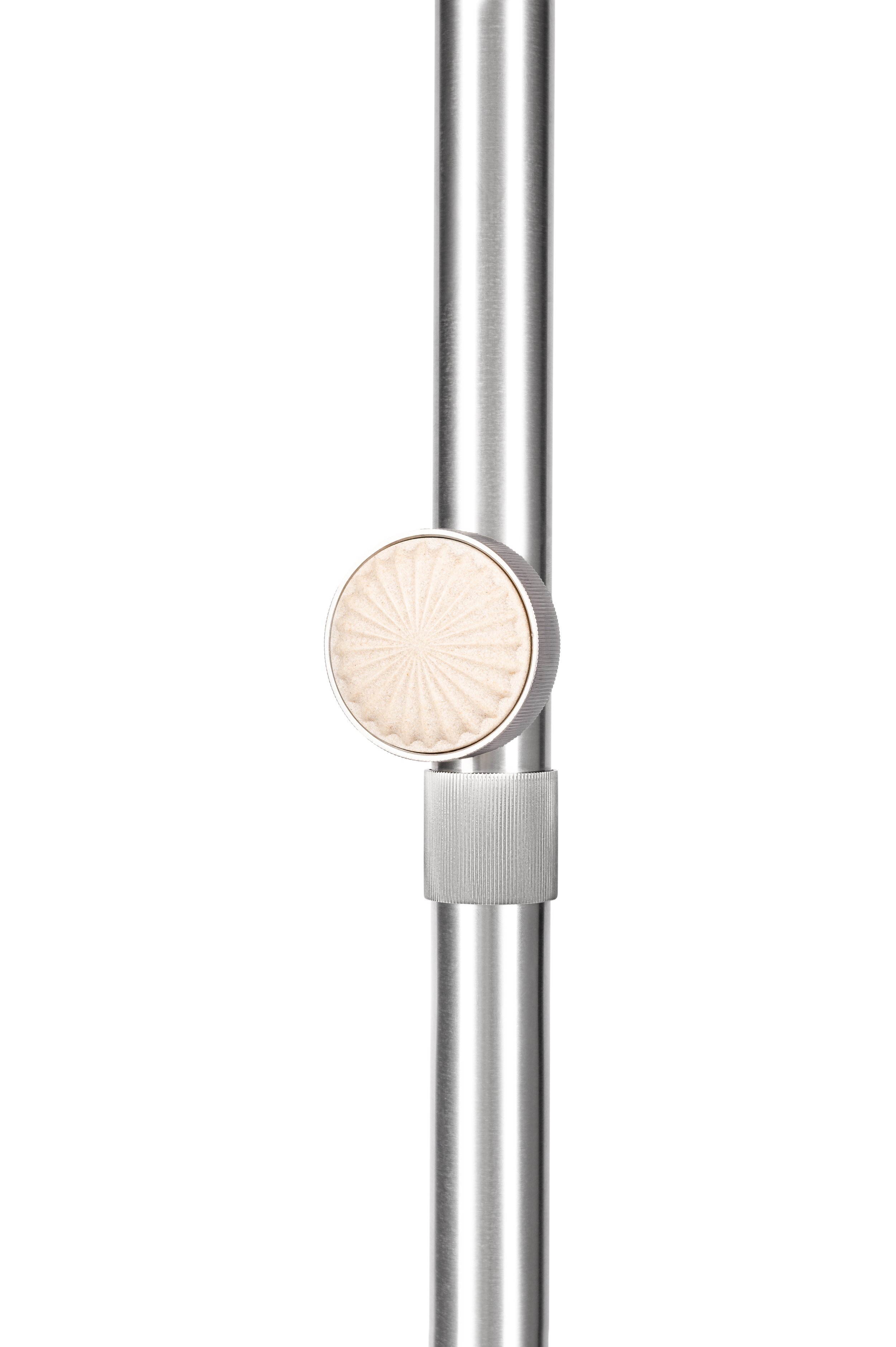 Close-up of a silver microphone stand with a beige, circular microphone attached to it.