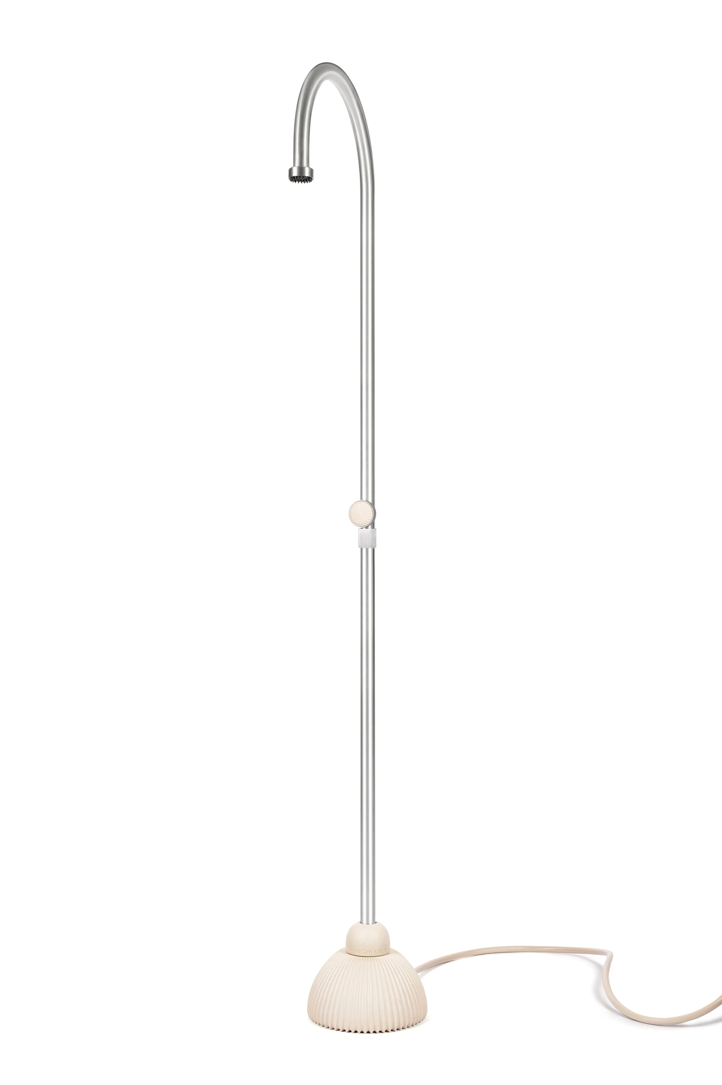 A modern table lamp with a beige ribbed base and a tall, curved silver stem with a small round light on top, and an attached beige cord.