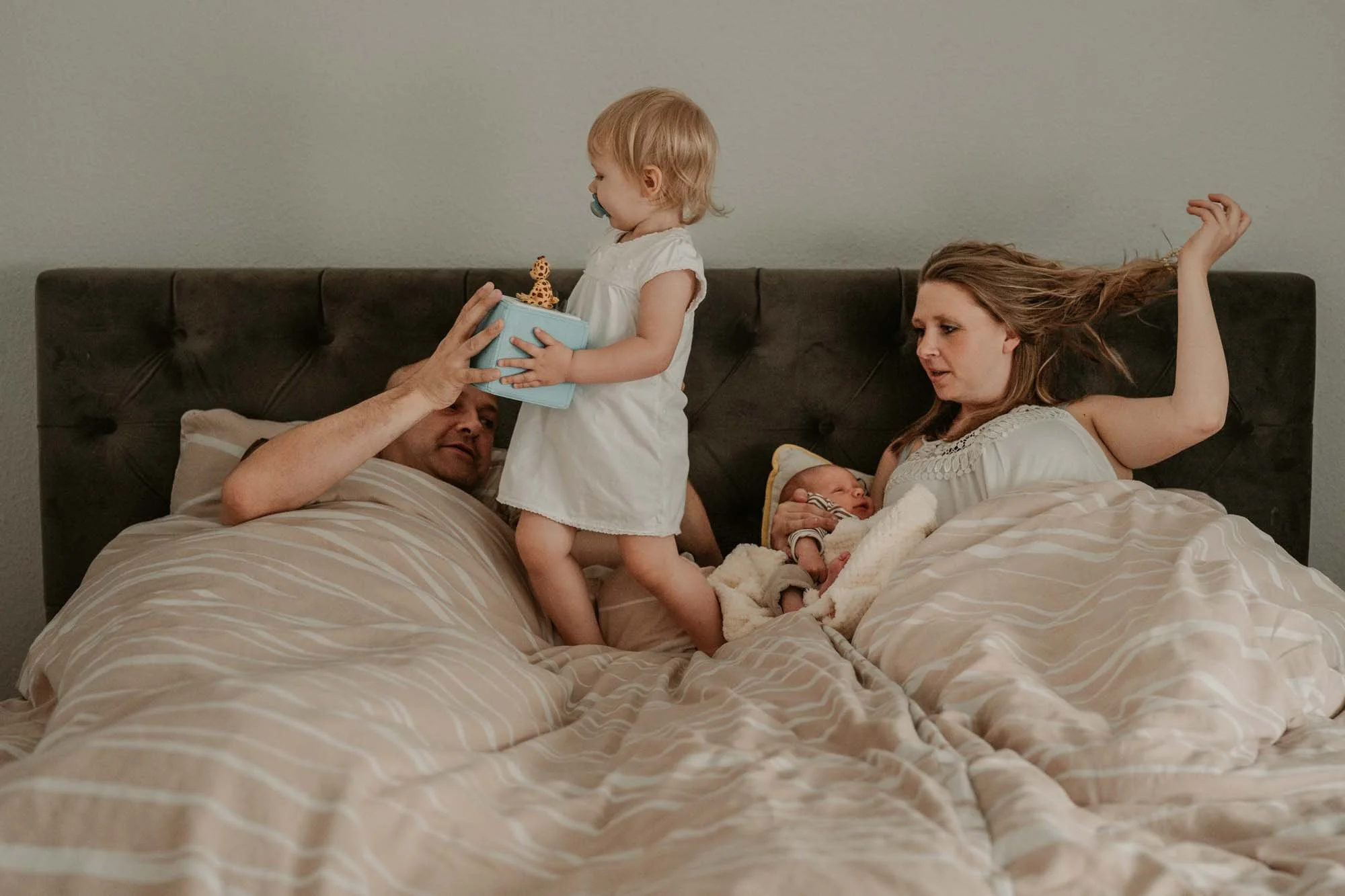 Natürliche Familienfotos zeigen echtes Wochenbett.