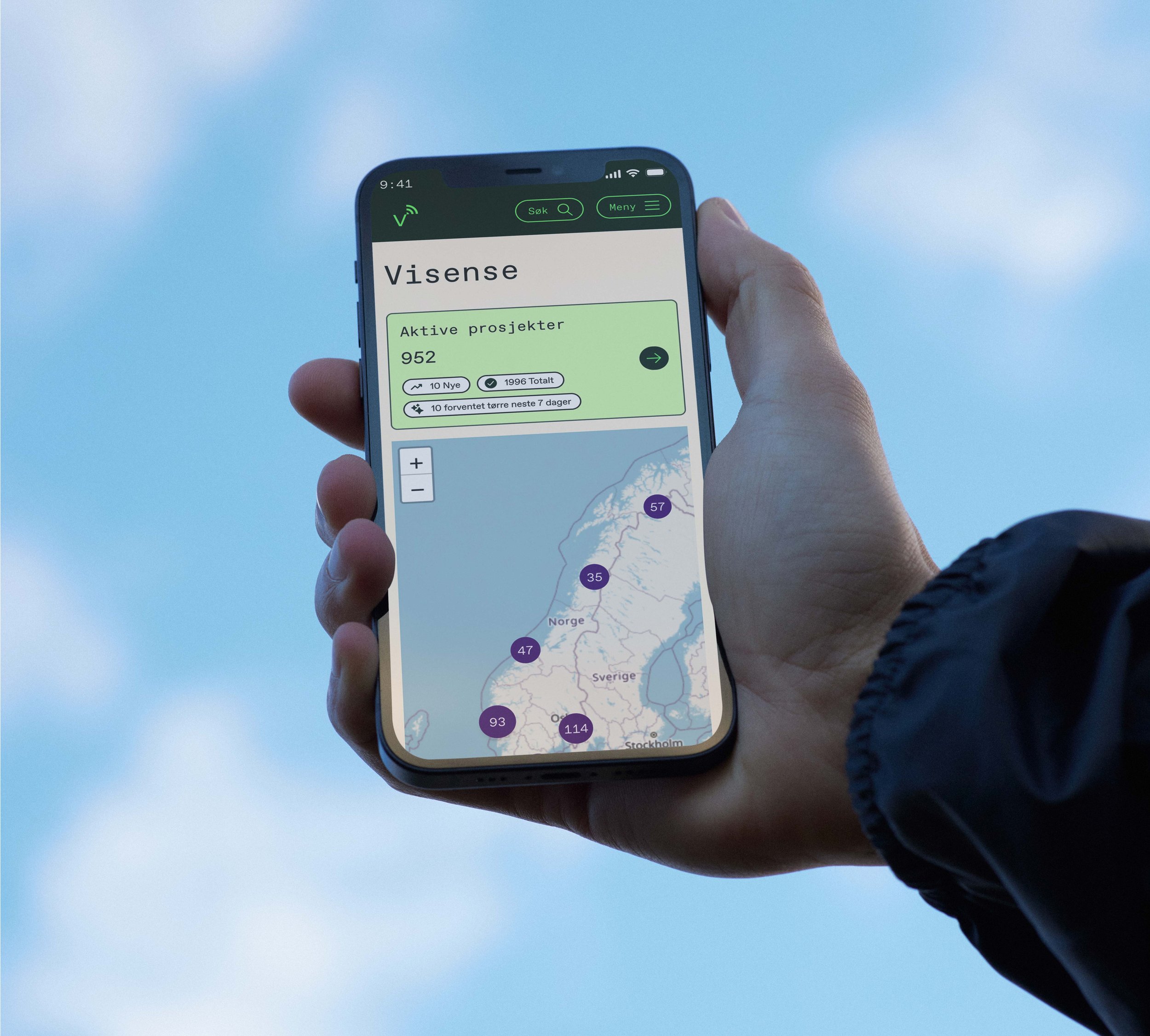 En person holder en smarttelefon som viser en app for visuelle prosjekter i Norge, med et kart og nummererte punkter.