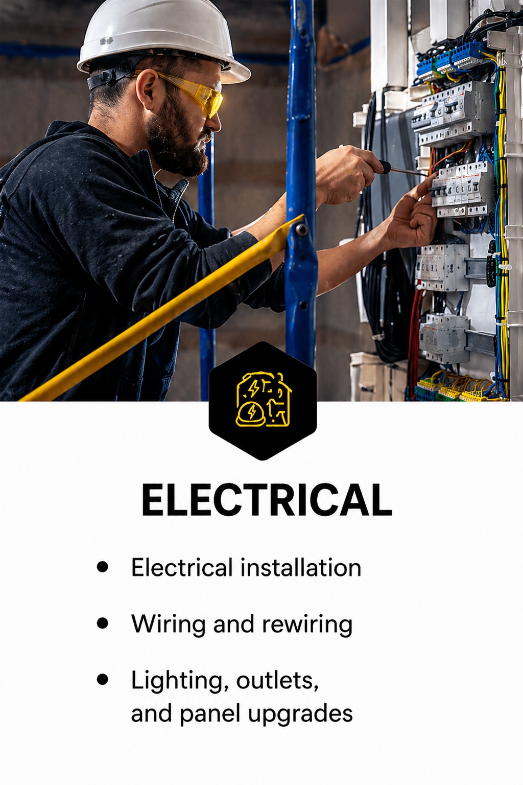 An electrician wearing a hard hat and safety glasses working on an electrical panel with wires and circuit breakers.