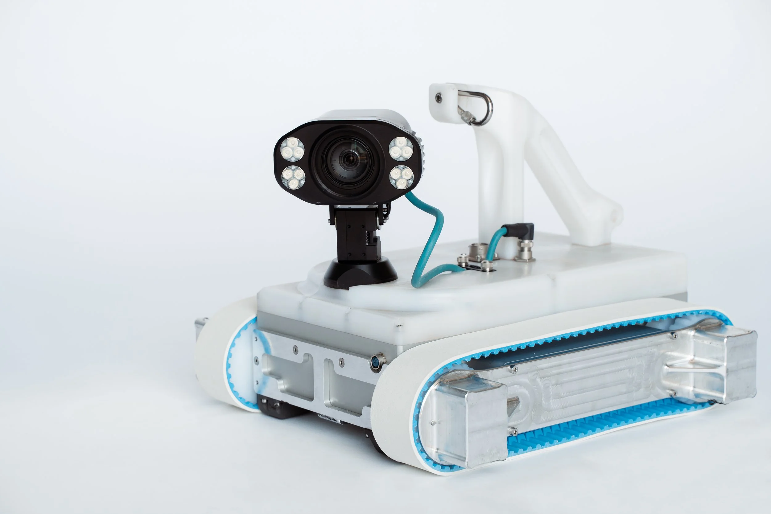 A Invert Robotics H2200 robot with tank-like treads, a mounted camera and multiple lights on its head, set against a plain white background.