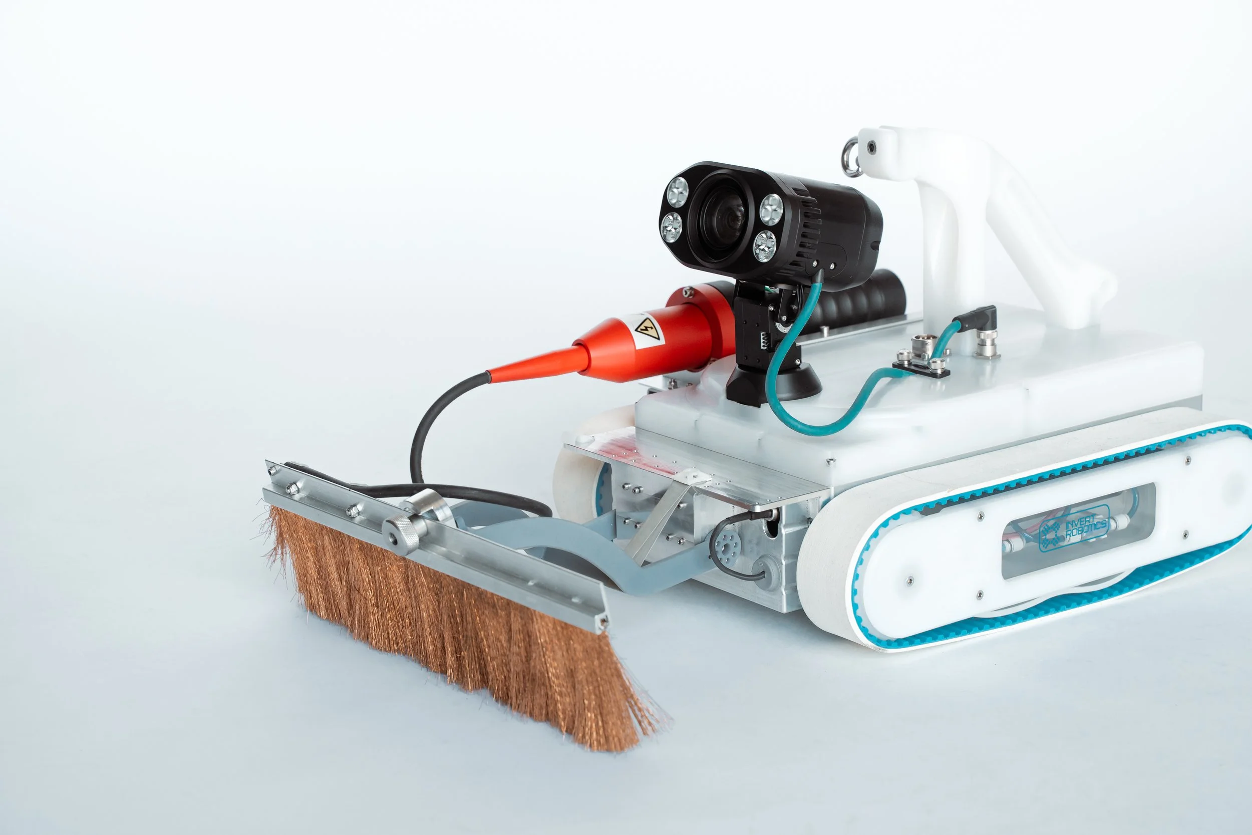 A n Invert Robotics robot with a white body and blue details, equipped with a camera and LEDs, holding a spark testing brush, designed for inspection tasks.