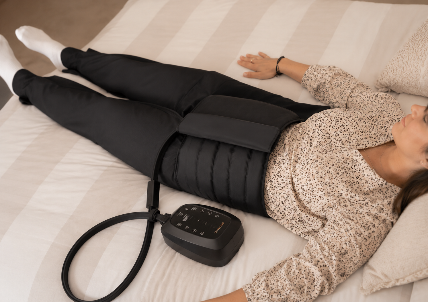 Woman lying on bed having compression therapy to help improve circulation.
