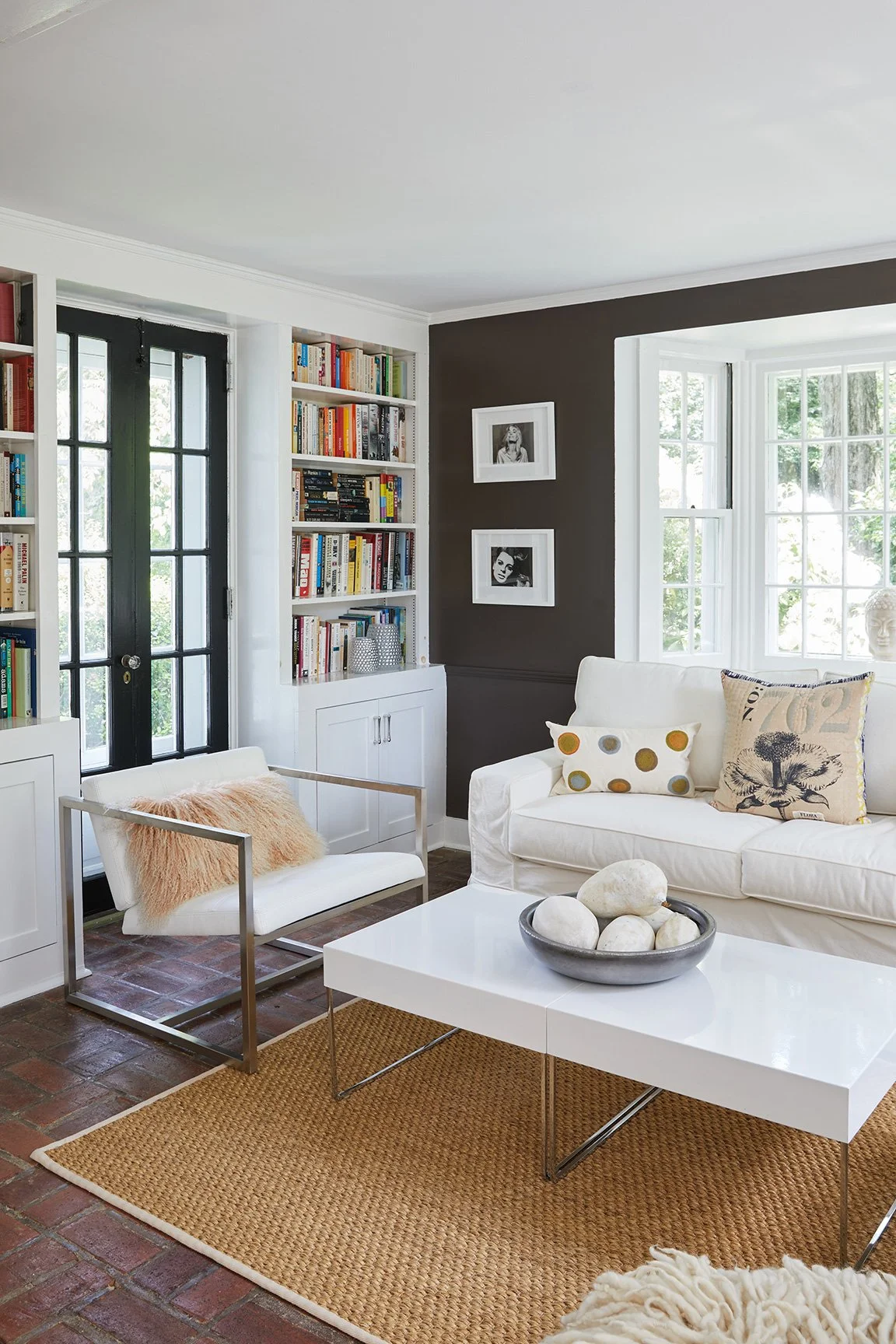 Reading corner with white sofa, chrome lounge chair, built-in bookshelves, and dark accent wall in a Darien CT eclectic home by Ginger Lemon Indigo
