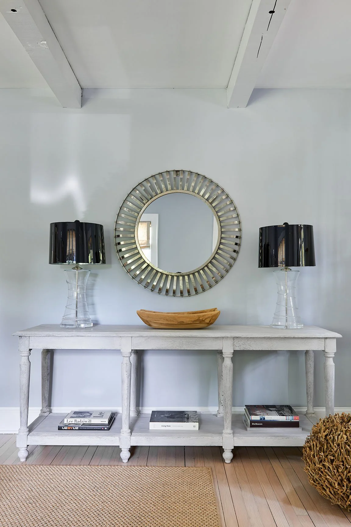 Styled entry console with sunburst mirror and paired table lamps in a Southampton NY interior design project by Ginger Lemon Indigo