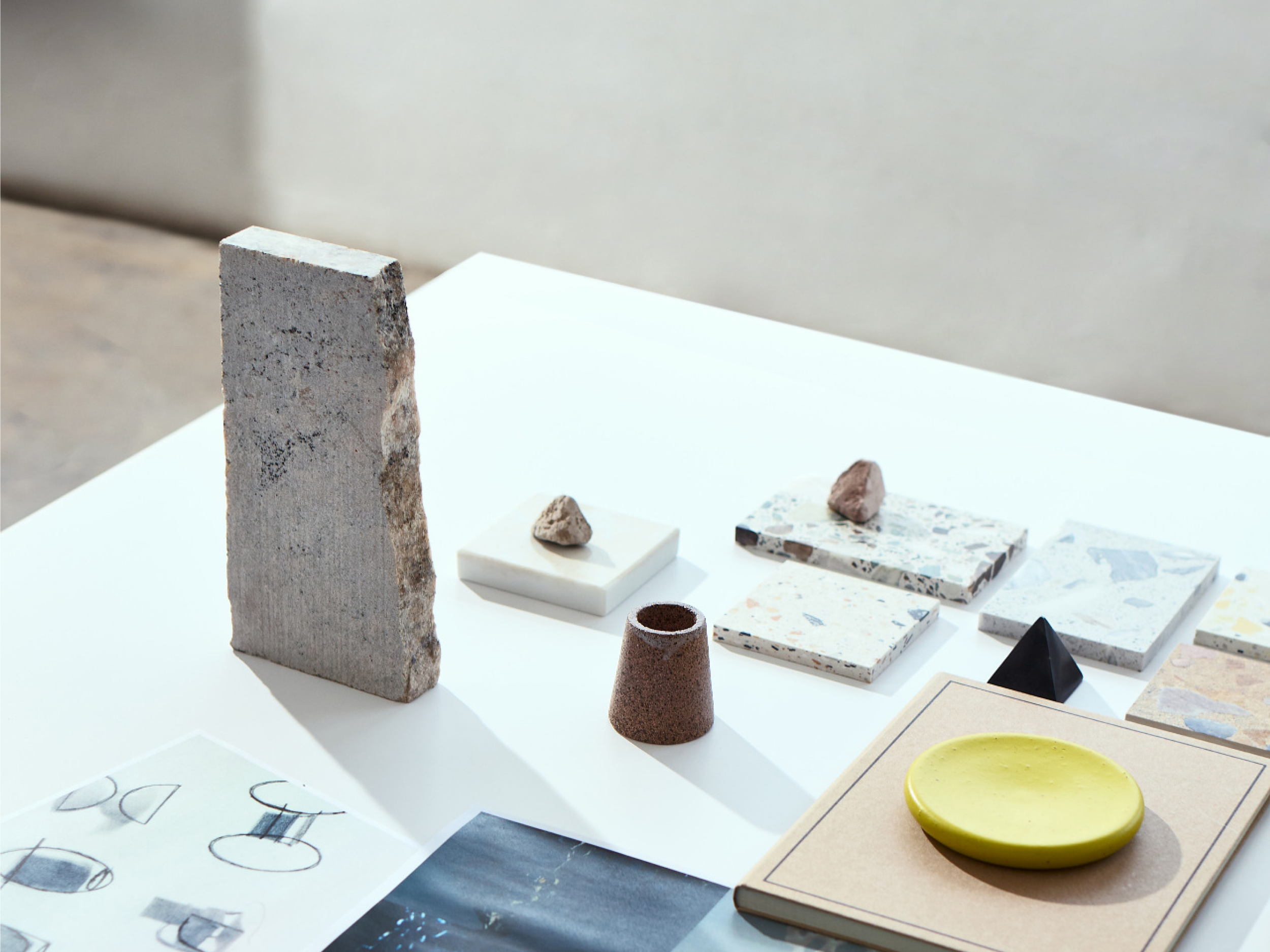 Countertop material samples in stone, marble, terrazzo and cork on a studio table