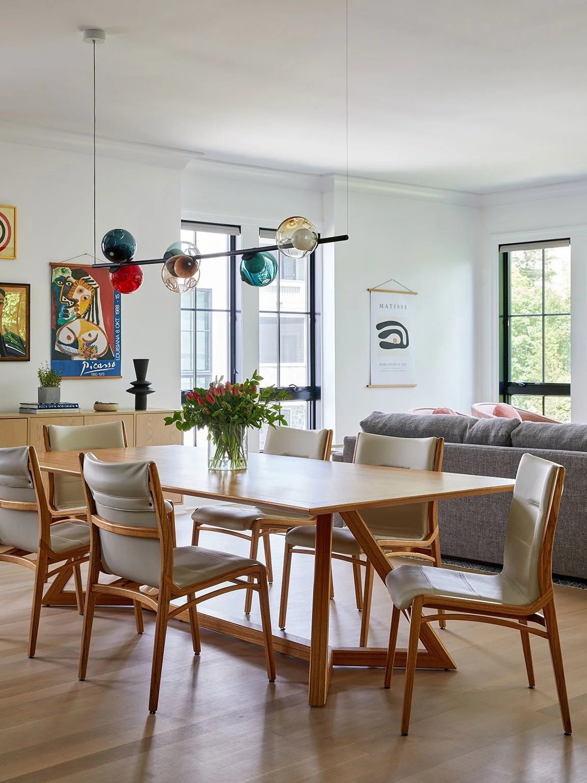 ZYV Table with Lily Chairs in Jequitibá wood beneath handblown multi-coloured glass pendant