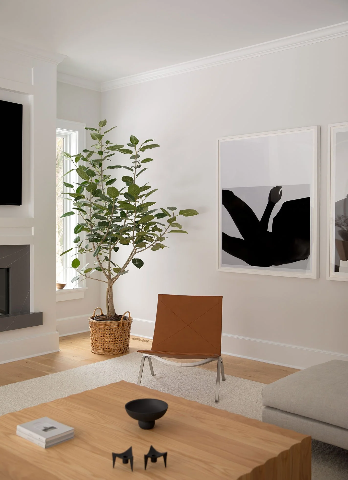 Nearby project from Ginger Lemon Indigo Westport CT family room with cognac leather PK22 chair, potted ficus tree in wicker basket, paired black abstract prints and oak floors