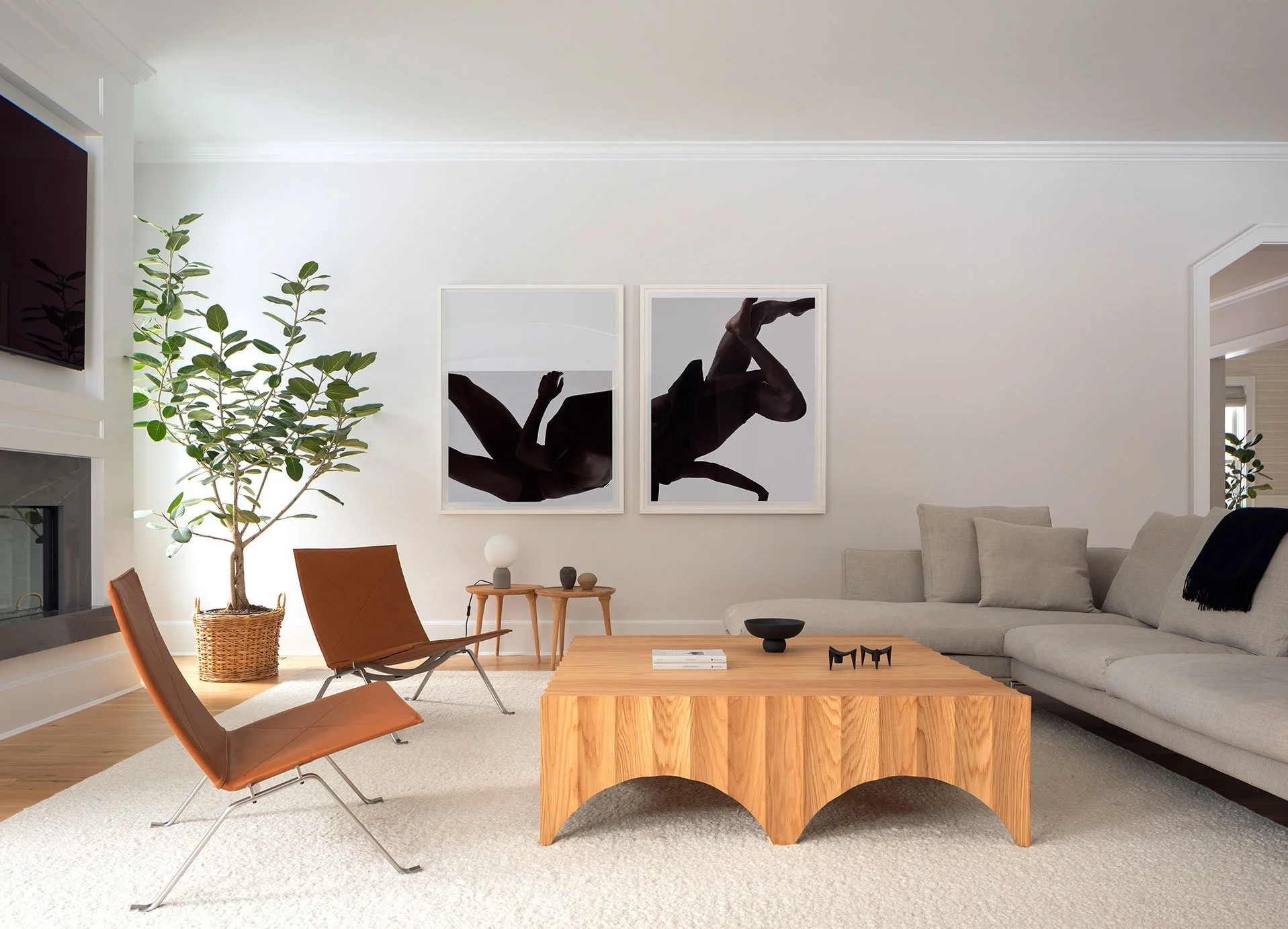 Westport CT family room with pair of cognac leather PK22 chairs, linen sectional, oak arched coffee table, ficus tree and paired black abstract prints