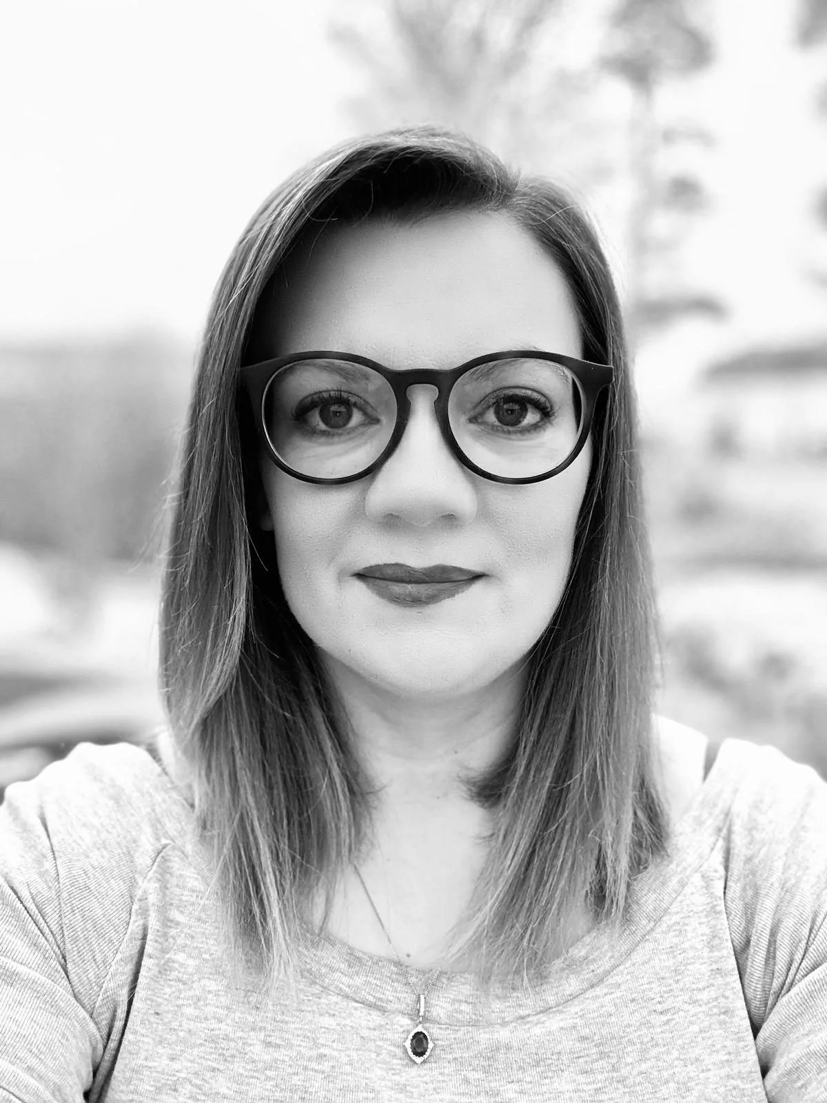 Black and white portrait of a person wearing glasses.