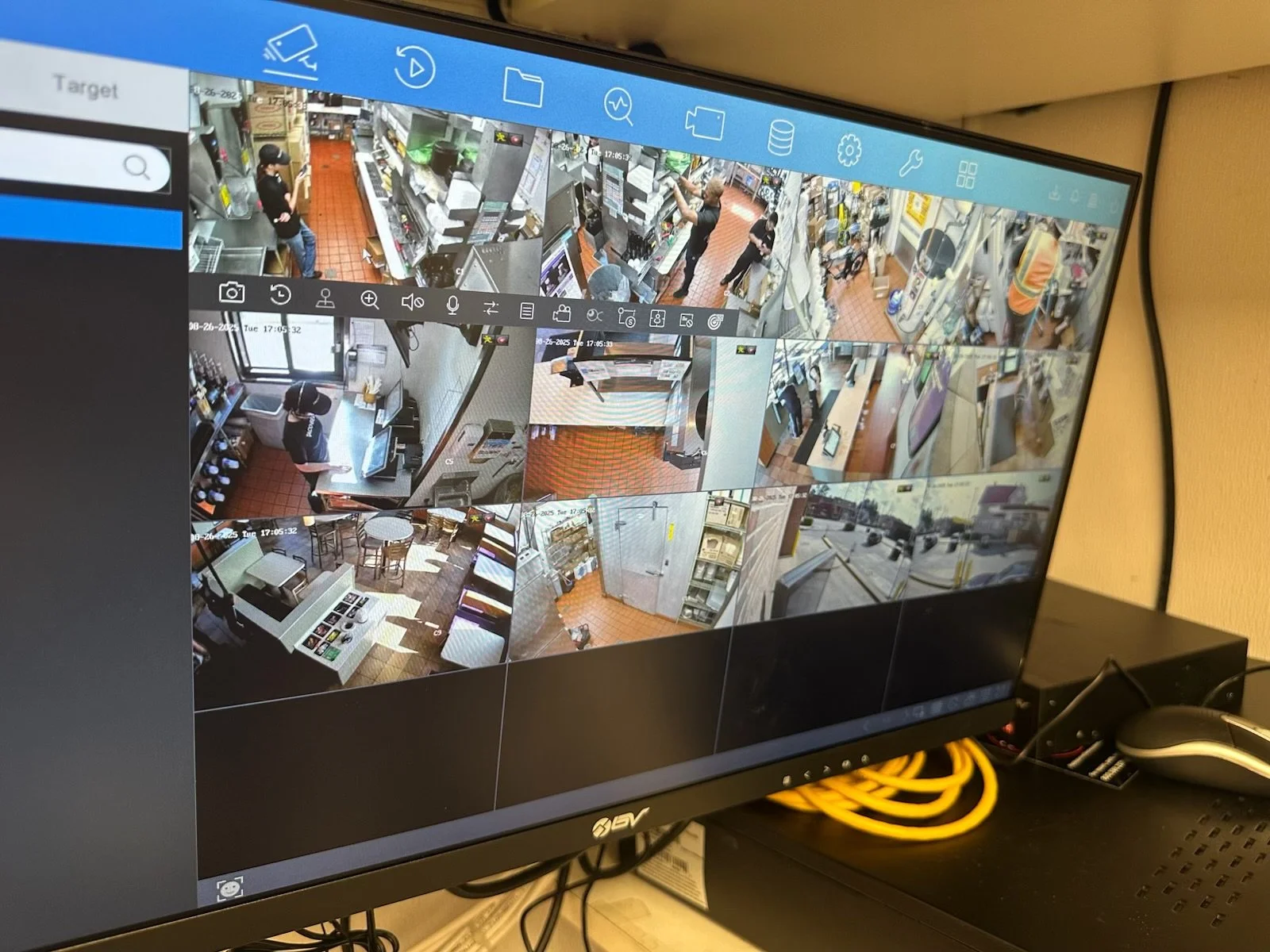 Surveillance monitoring screen showing multiple camera feeds of various indoor and outdoor scenes.
