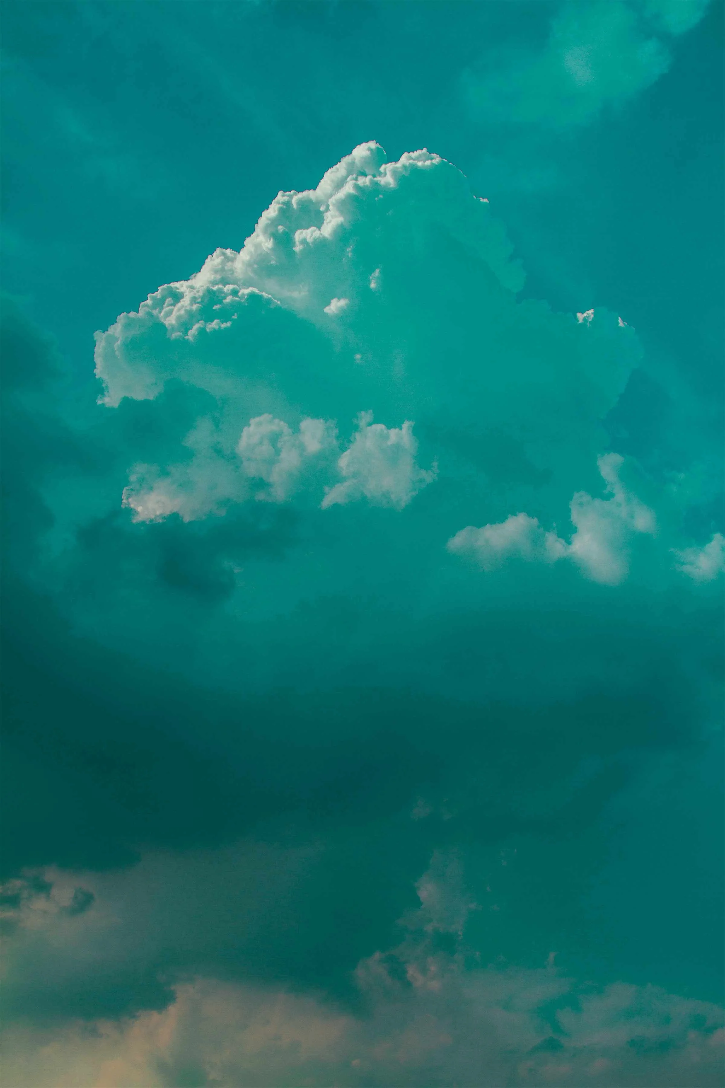 Clouds catching sunlight against a teal sky.