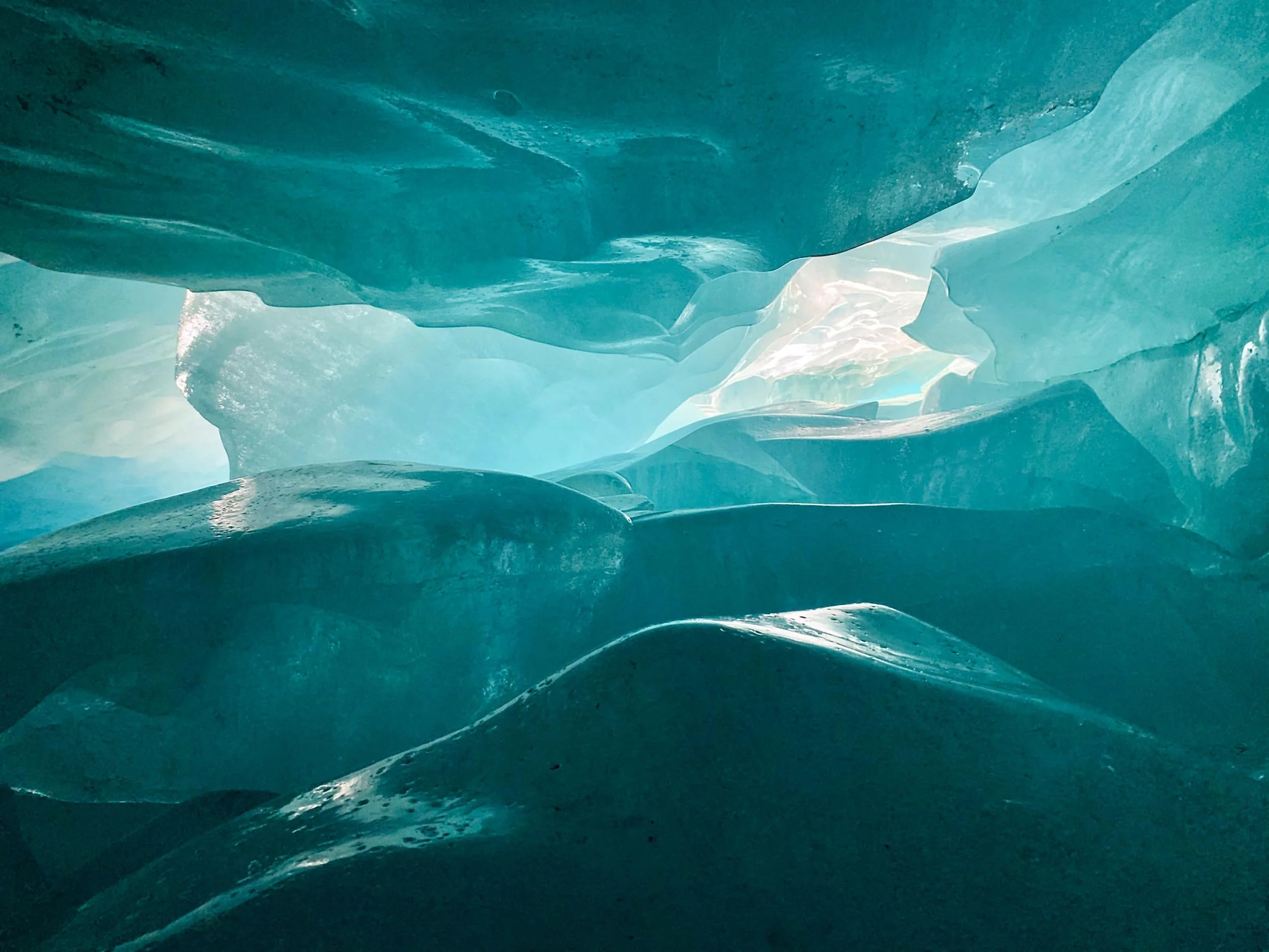 The interior of a translucent blue ice cave.