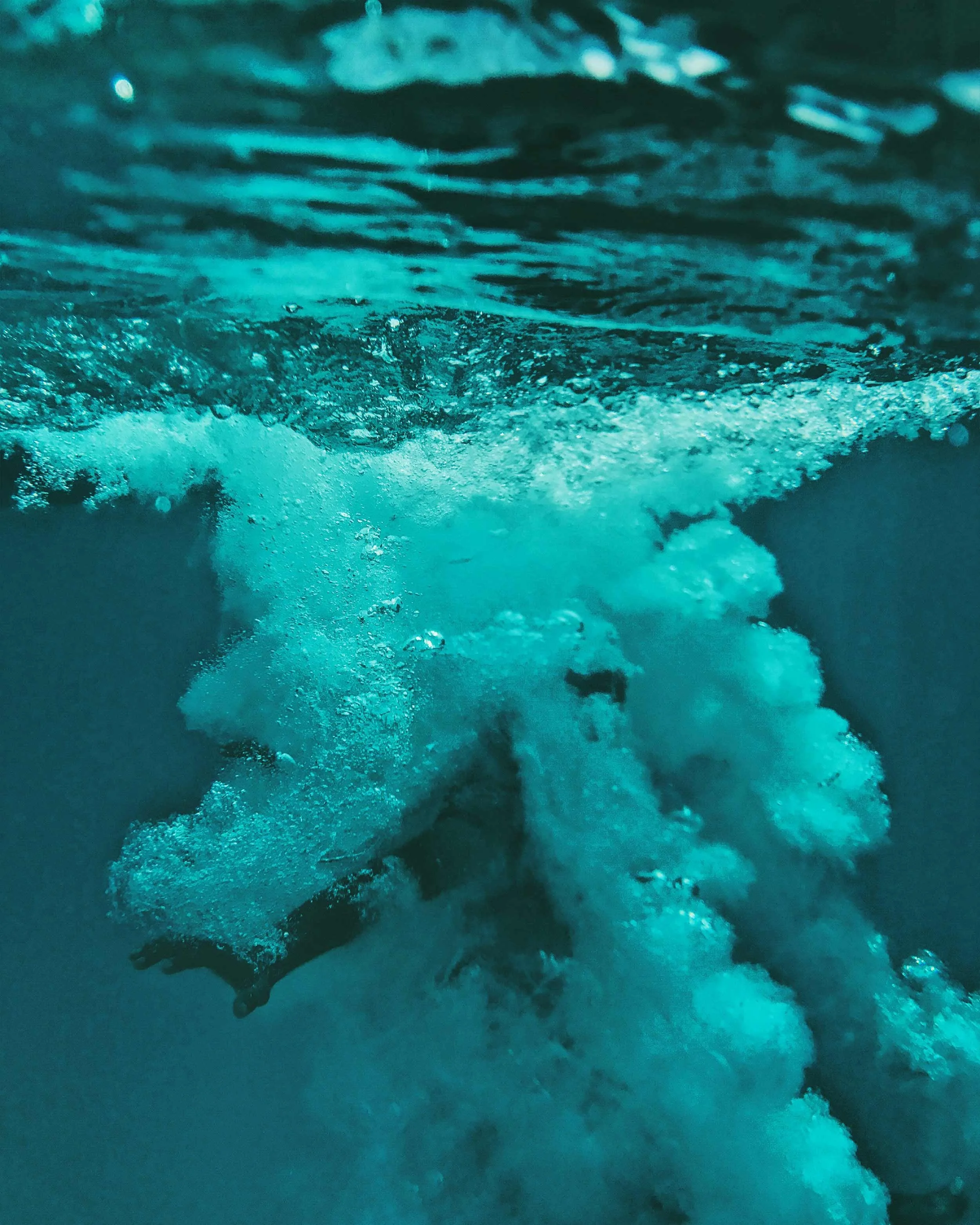 A splash of water captured mid-impact around a person diving.