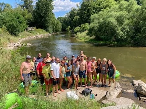 Group of tubers relaxing on a scenic Michigan river.