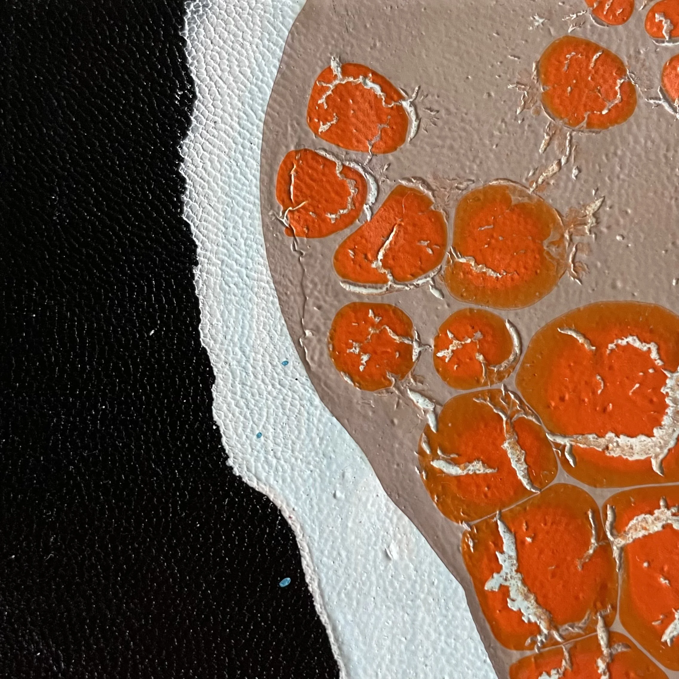 Close-up of painted orange flowers on a textured surface with black, white, and beige sections.