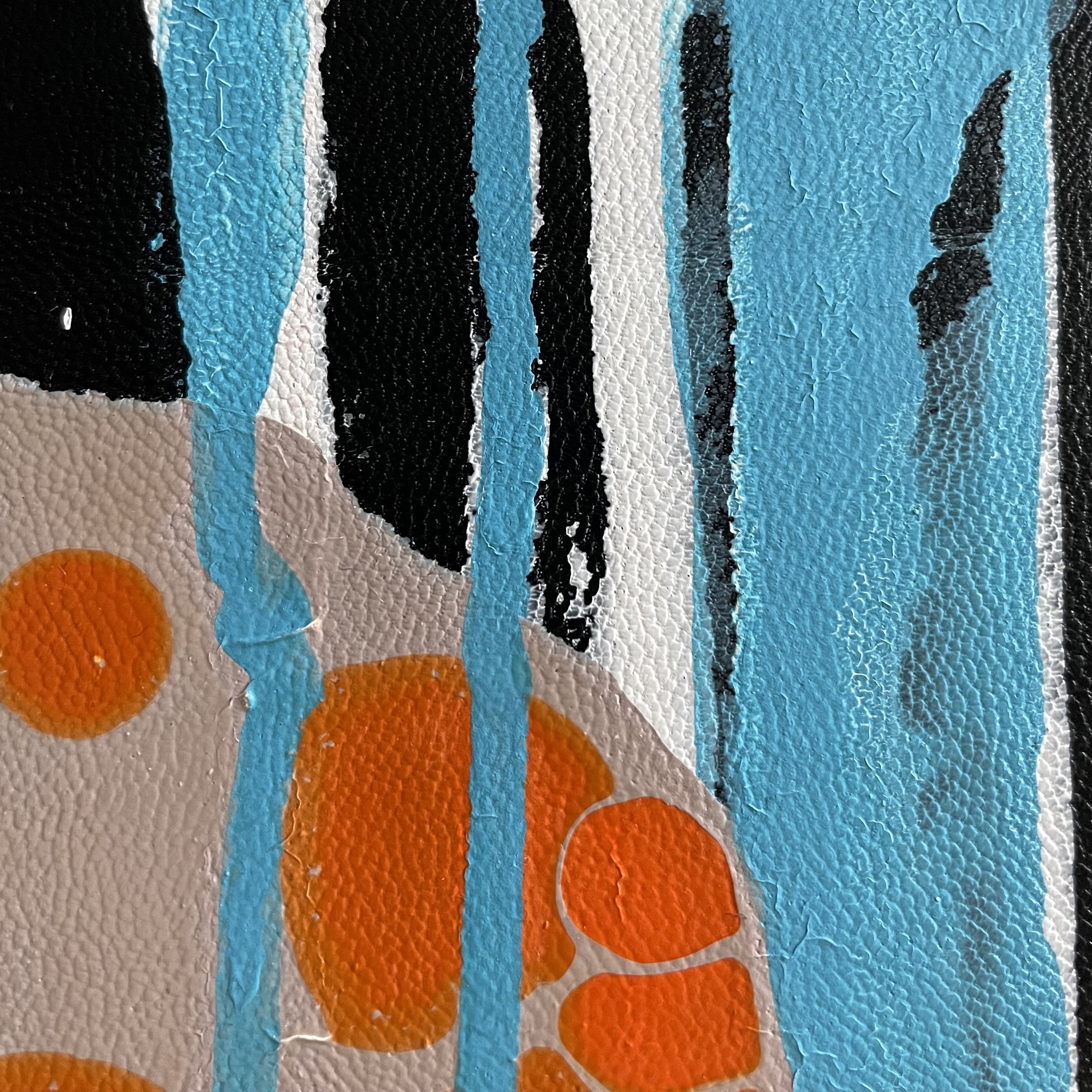 Close-up of textured graffiti art with black, blue, white, orange, and beige colors on a wall.